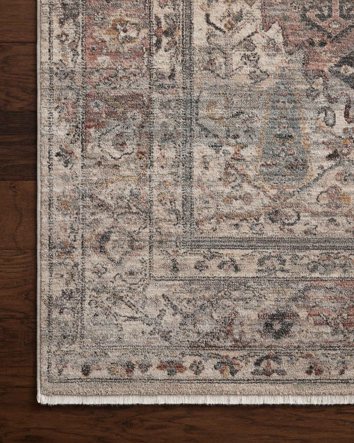 Close-up of distressed area rug motif with short fringe edge in silver gray tones