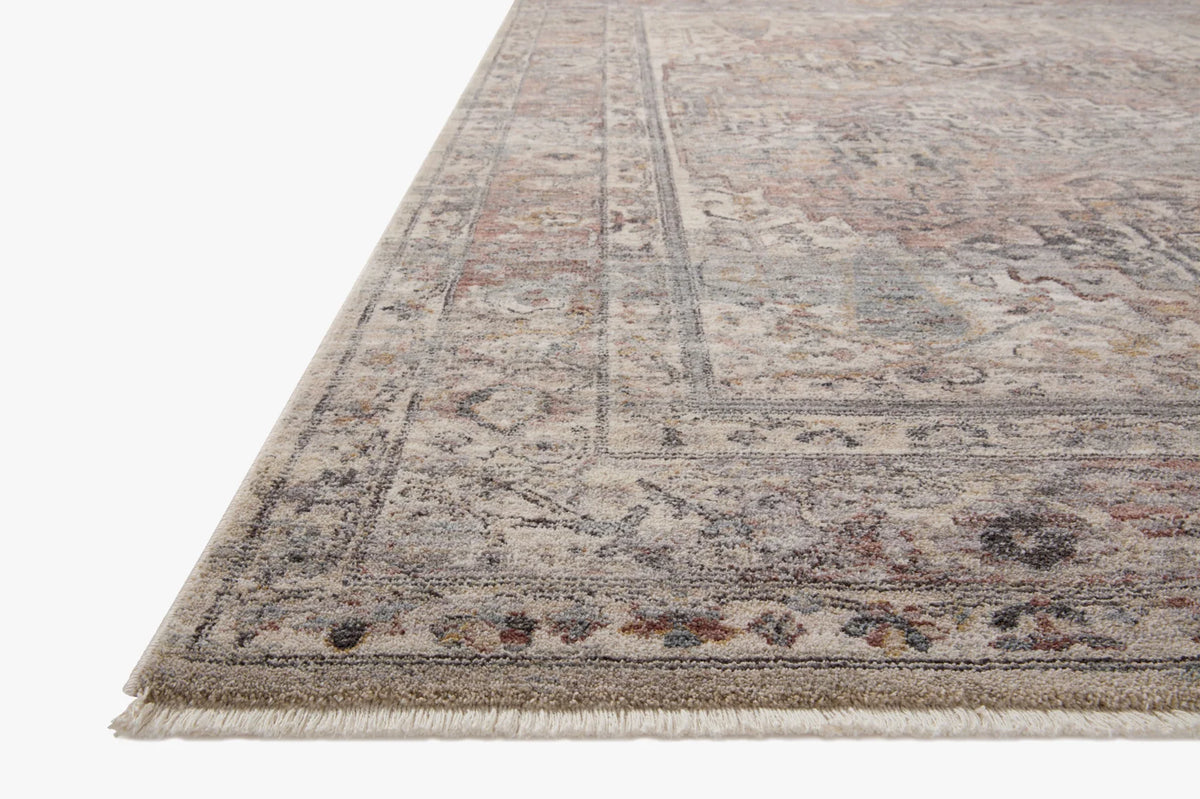Round area rug with distressed medallion pattern in light gray and muted rust tones