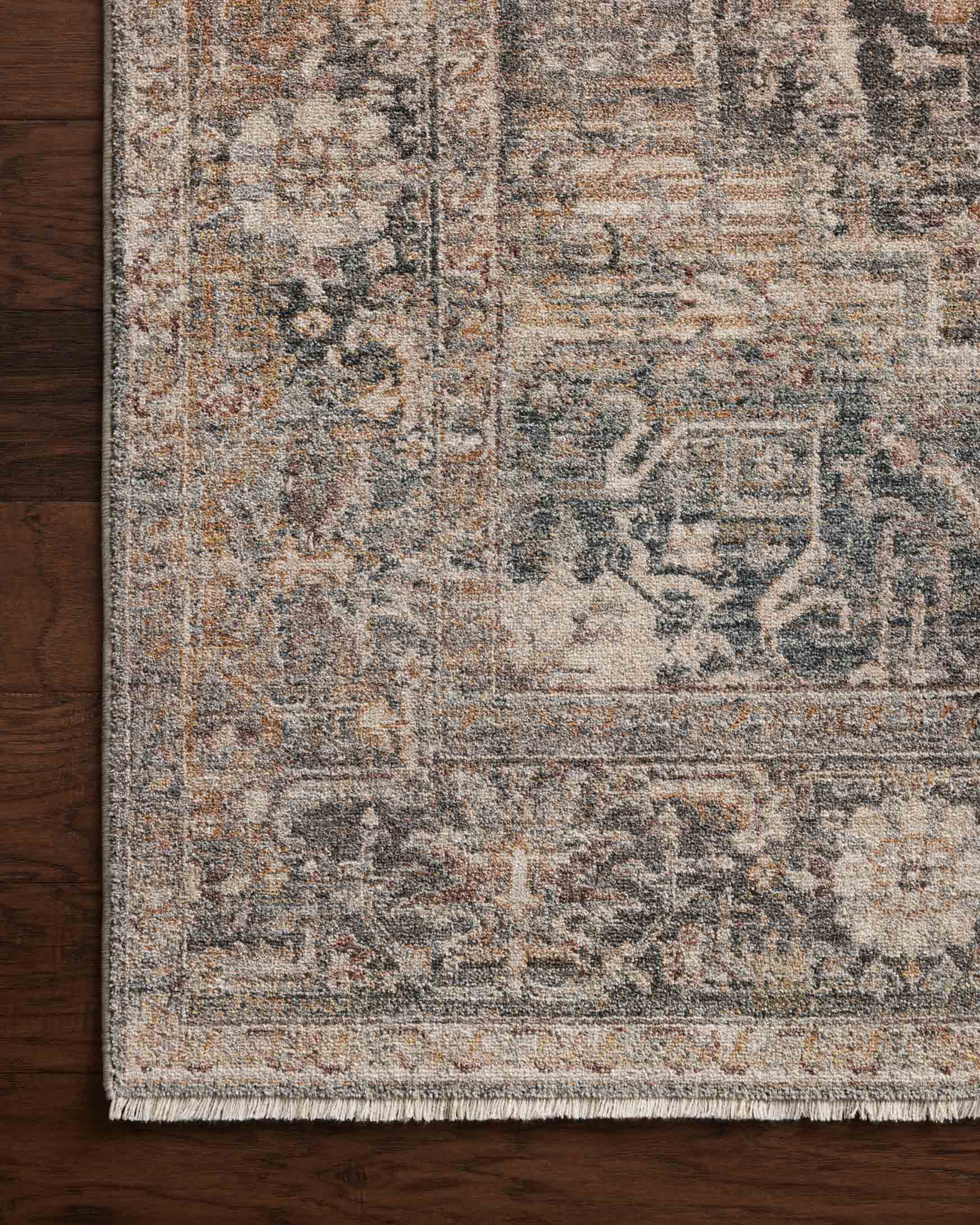 Close-up of distressed area rug border in blue-gray and tan with fringe edge