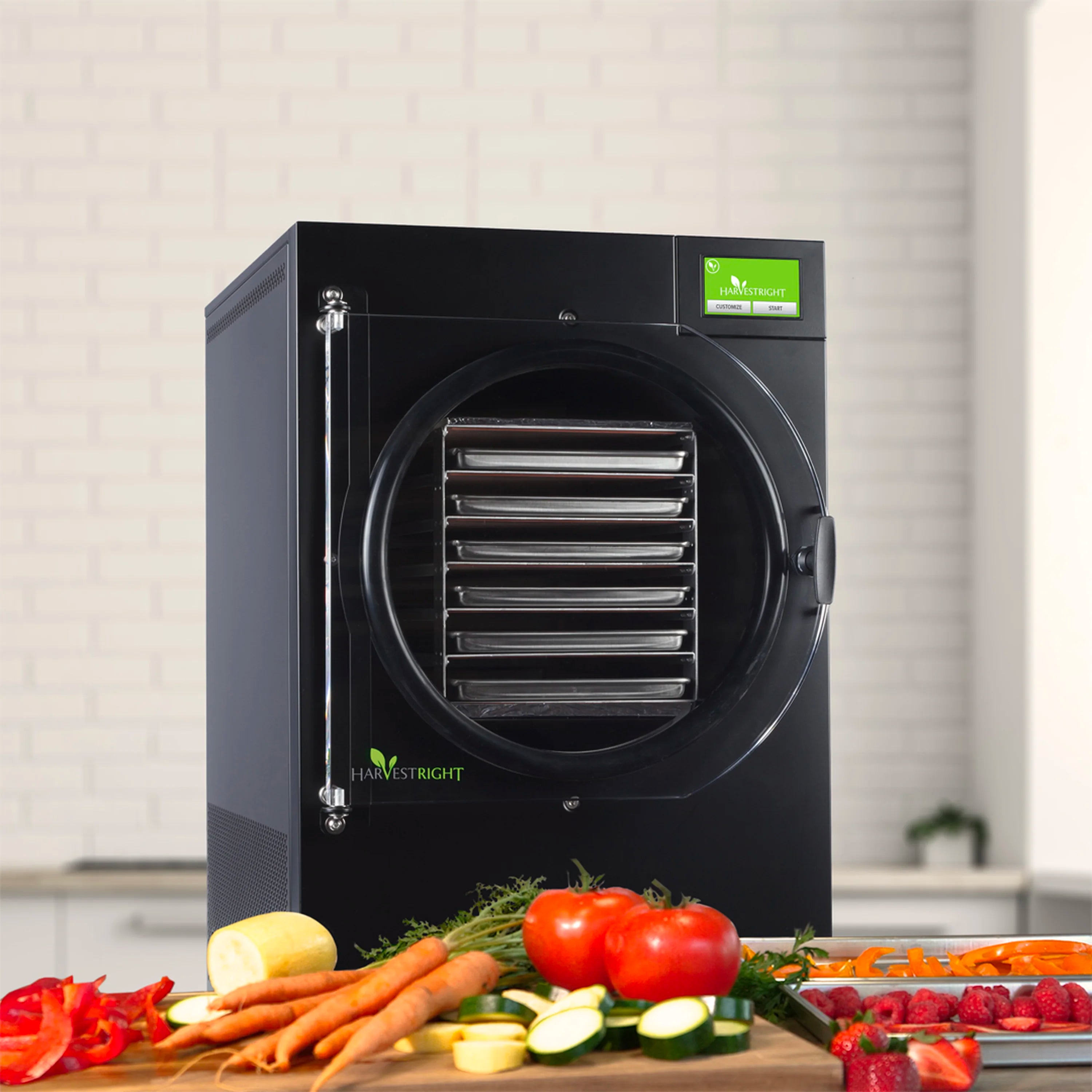 Black home freeze dryer with front chamber and fresh vegetables in front of unit