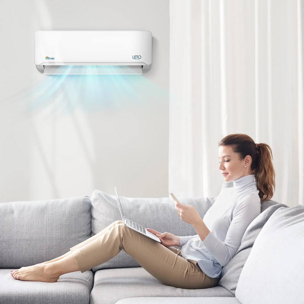 White Senville LETO wall-mounted mini split air handler with blue airflow, person using remote