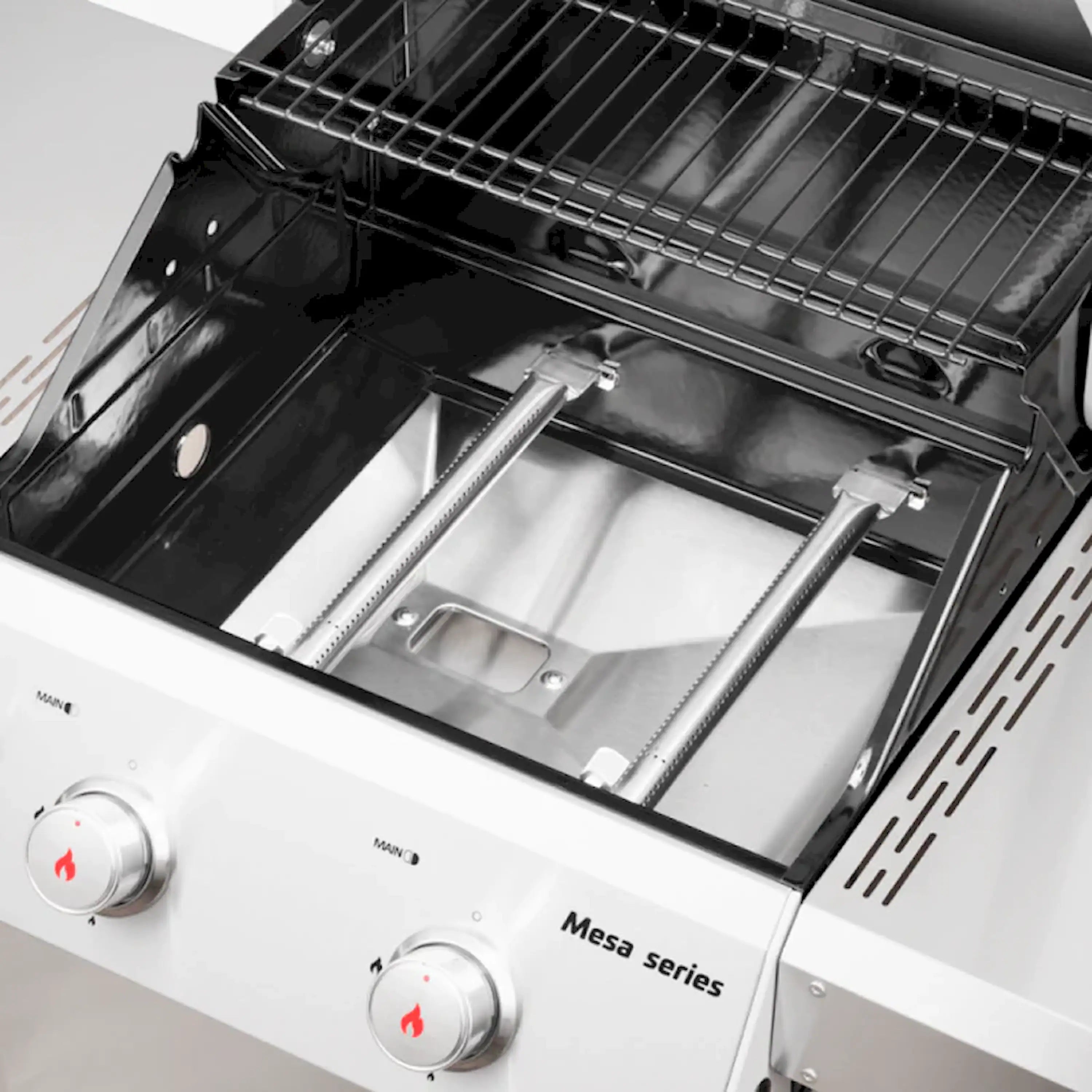 Stainless steel propane grill open lid showing burner tubes and grease tray