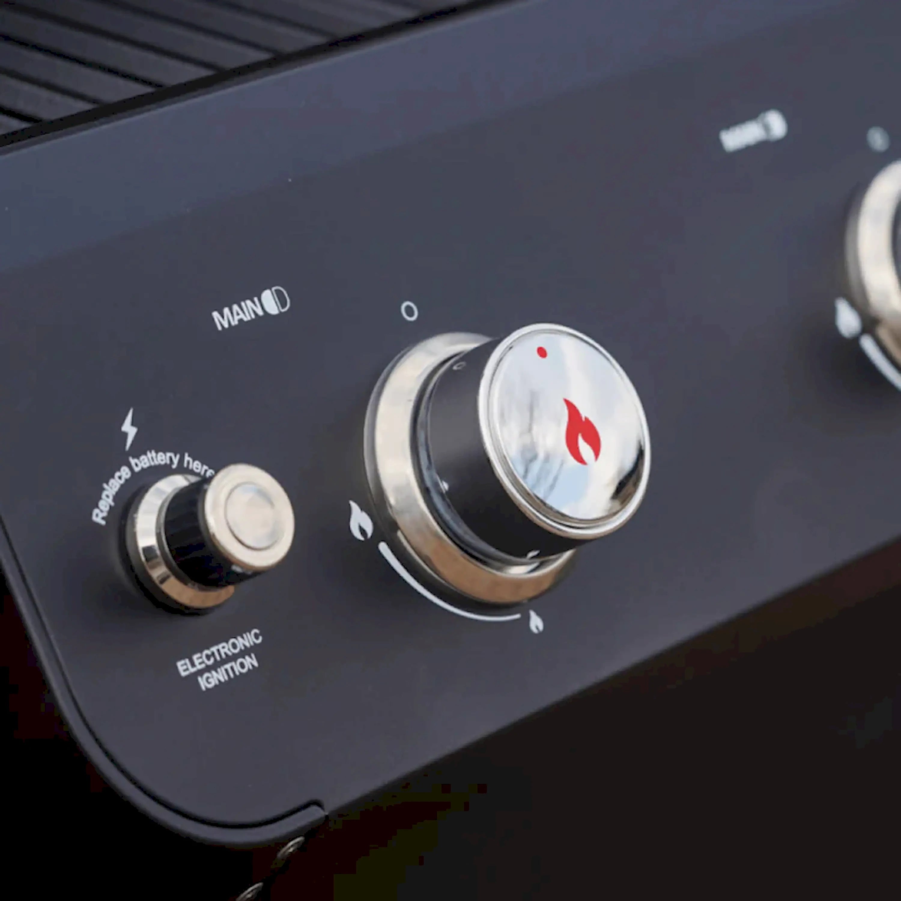 Black propane grill control panel with two round knobs and flame indicators