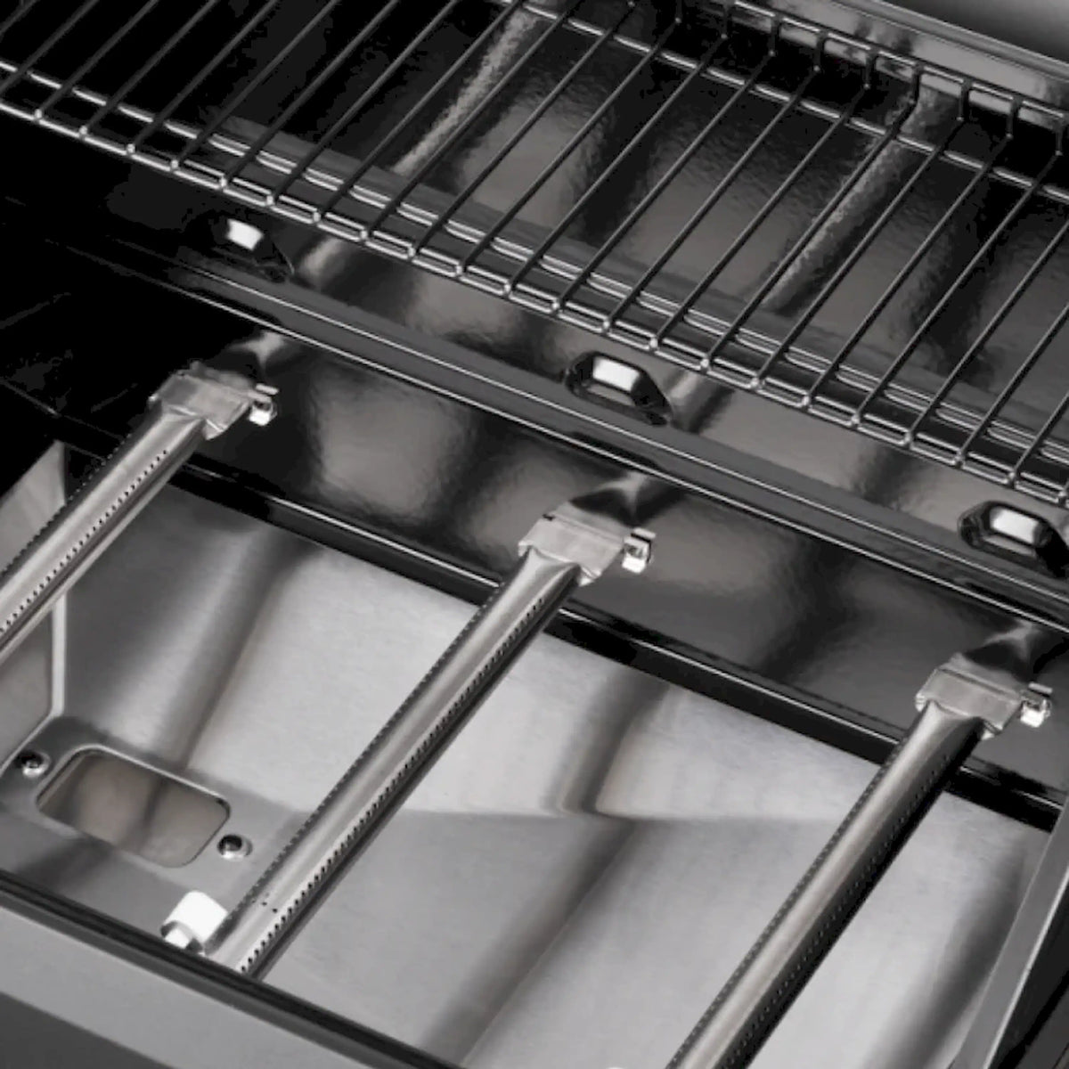 Inside of a black gas grill with stainless cooking grates and flavorizer bars