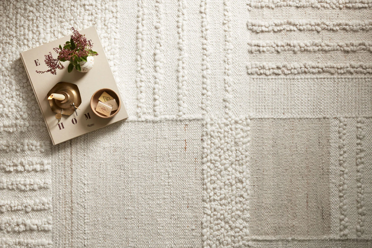 Ivory rug close-up with raised stitch ridges and pebble-gray accents