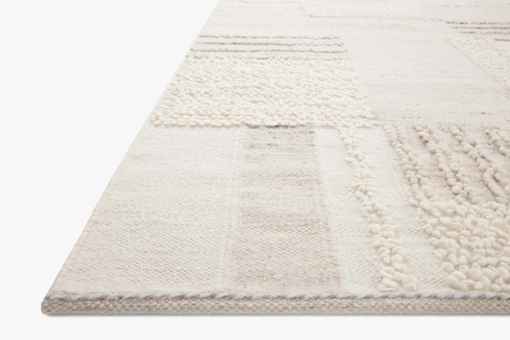 Ivory area rug with textured loop pile and muted pebble geometric pattern border