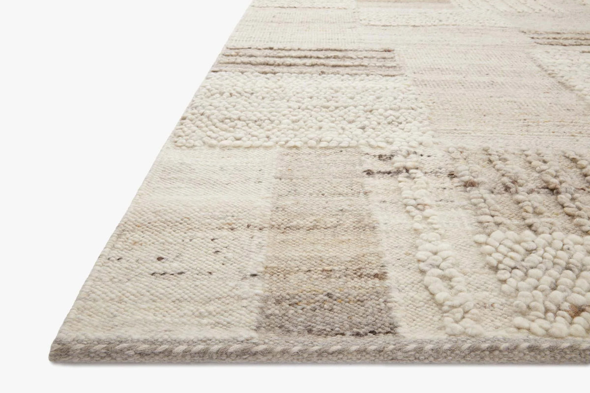 Textured natural area rug with stone-gray patchwork blocks and looped pile corner