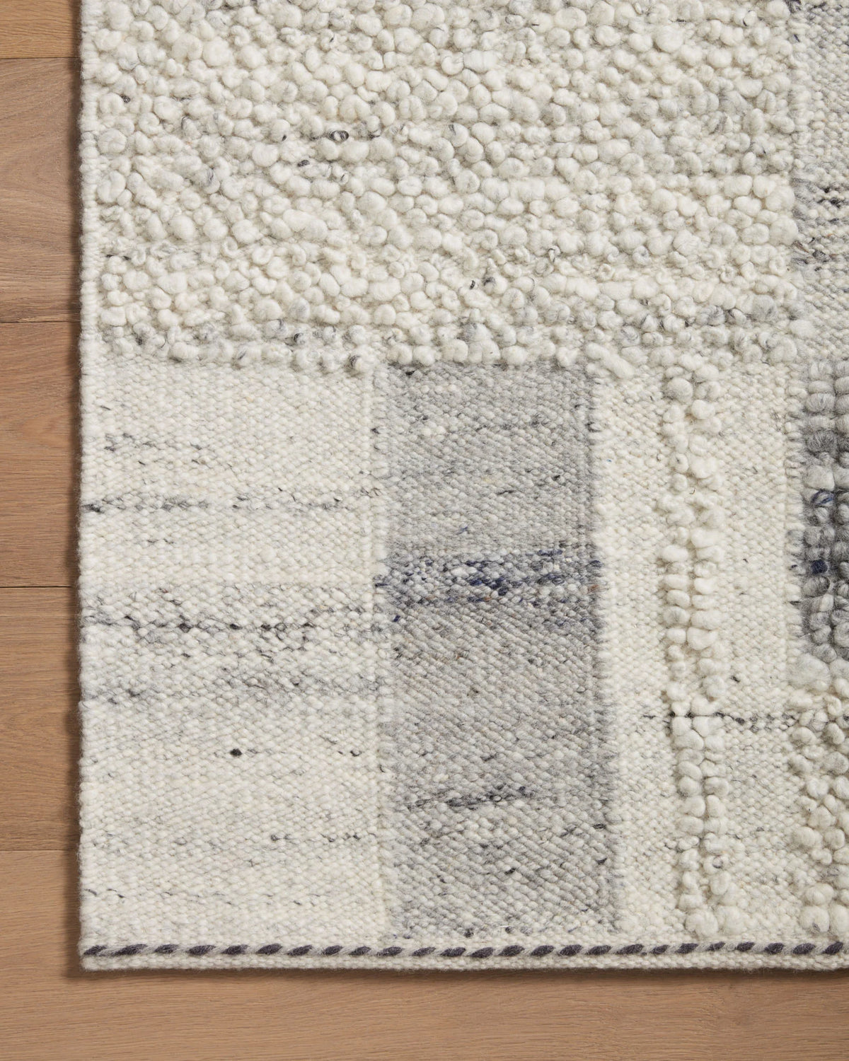 Runner rug corner with slate-gray and light geometric blocks, textured looped pile