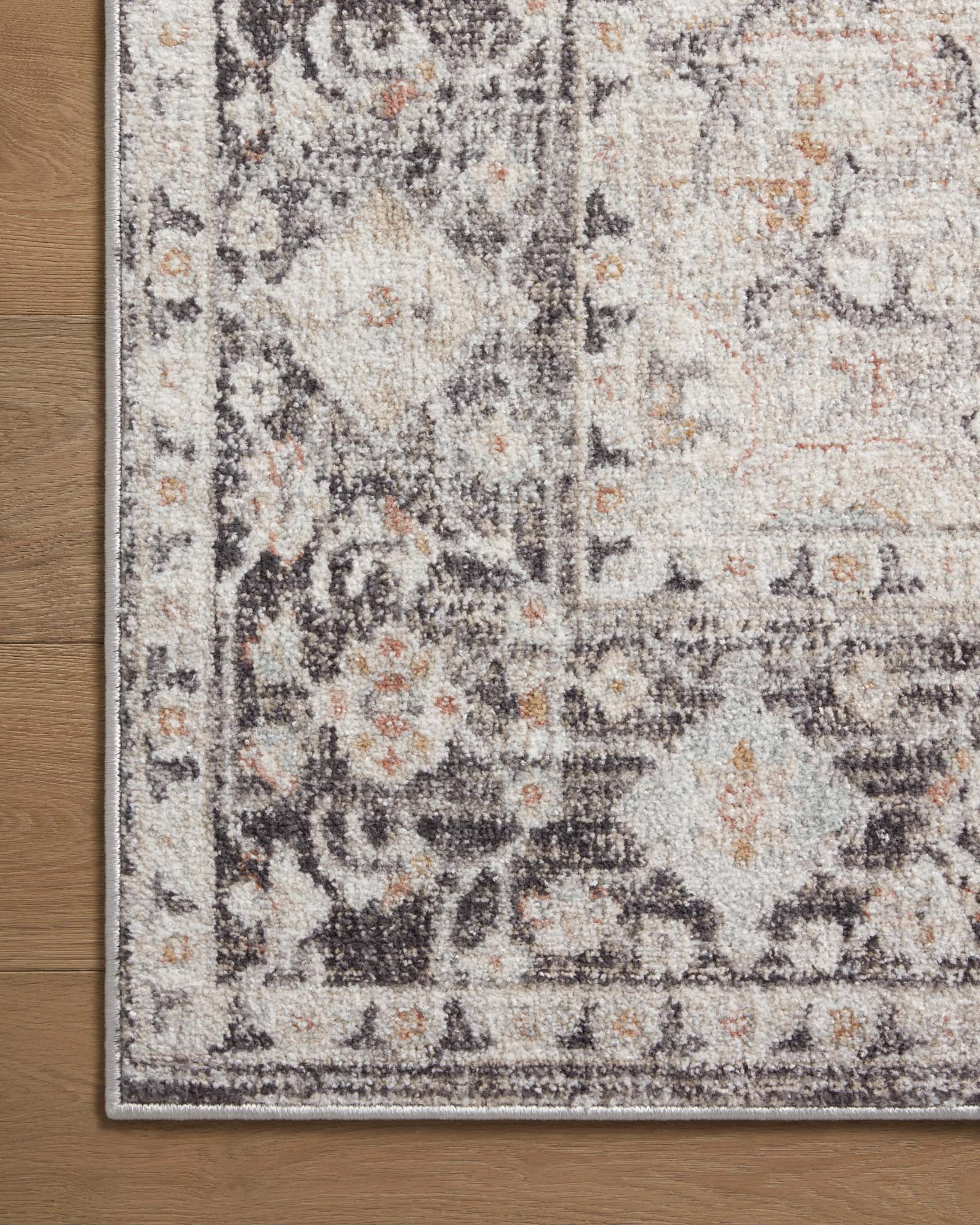 Close-up of distressed gray runner rug with ornate motif and detailed border edge