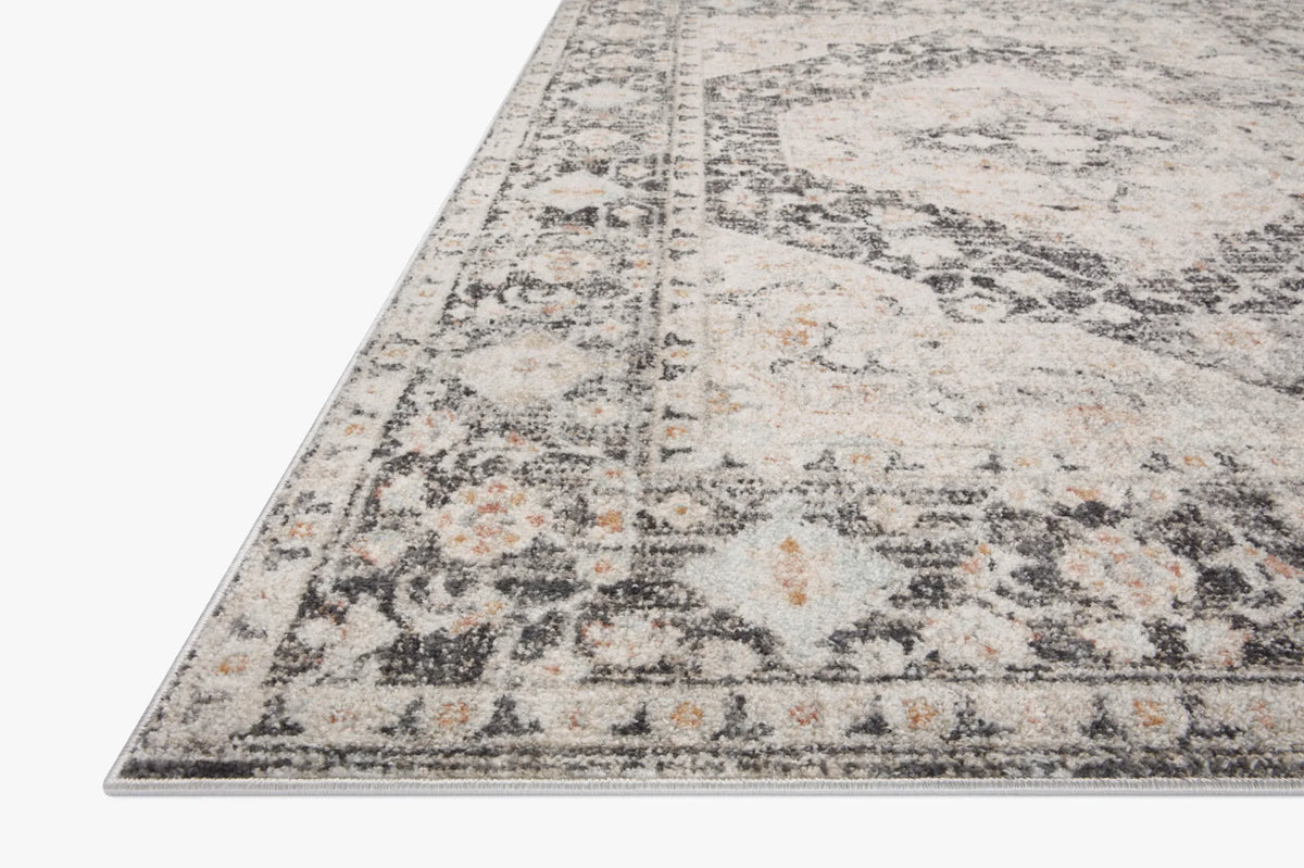 Charcoal area rug with distressed abstract pattern and short, flat weave texture.