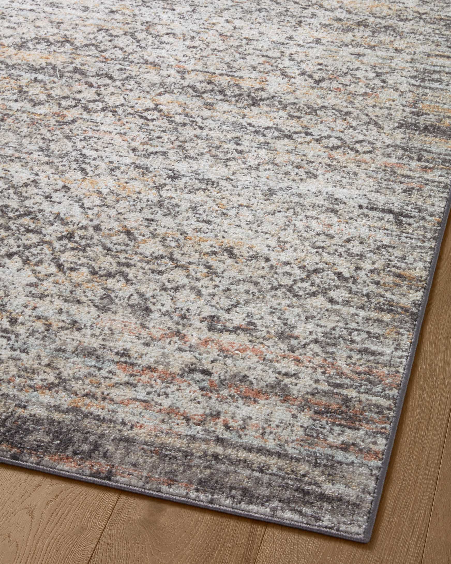 Gray accent rug with horizontal bands of distressed pattern and multicolor flecks.