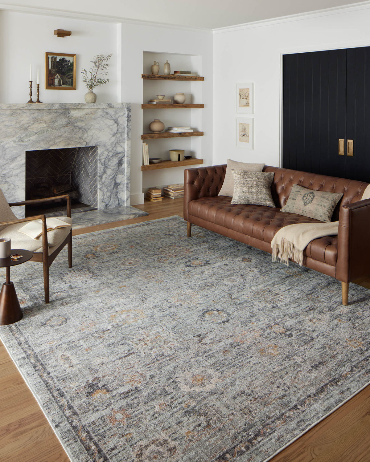 Large light gray area rug with muted sky blue and gold distressed abstract pattern