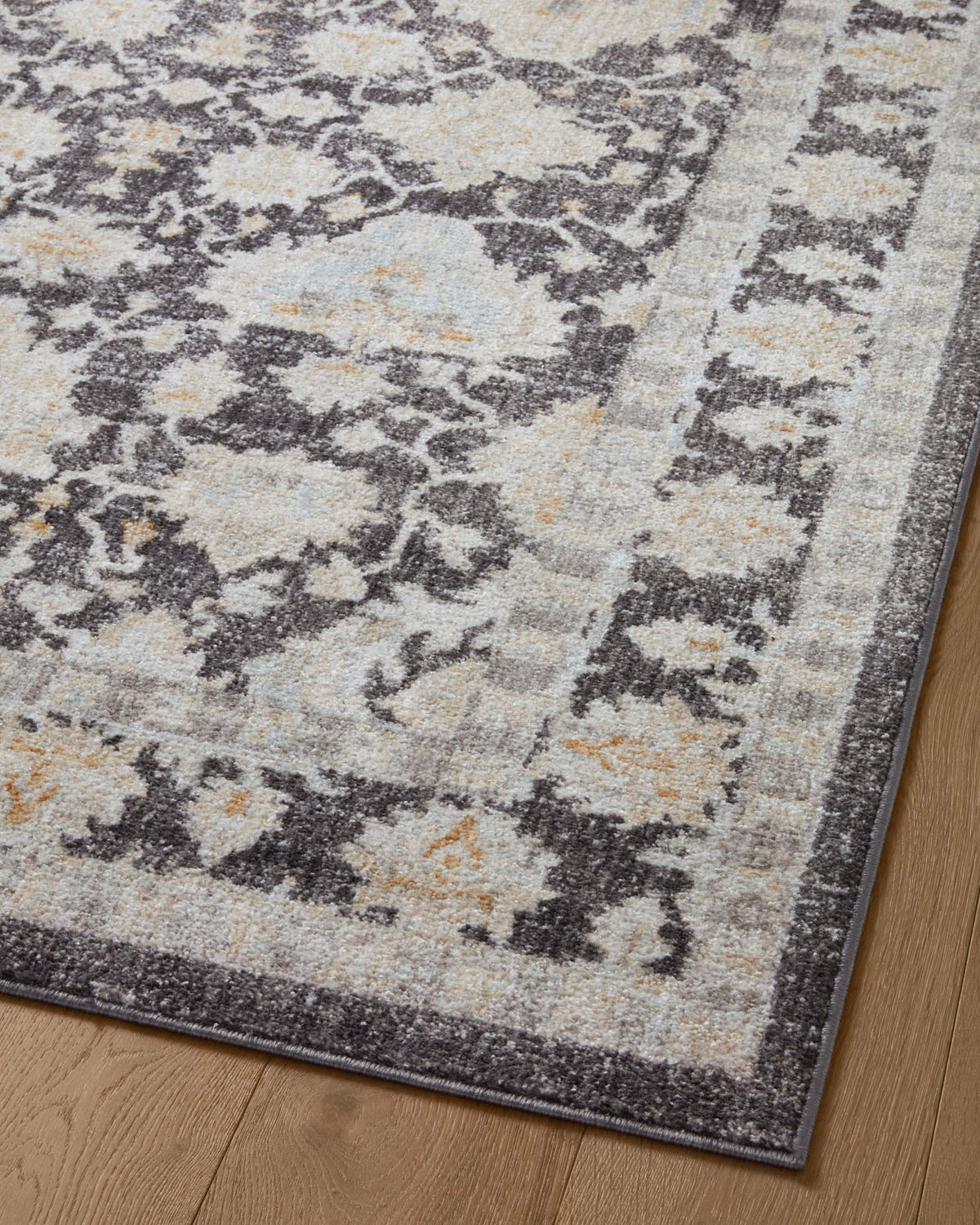 Charcoal and natural area rug with scattered medallion pattern and dark outline border