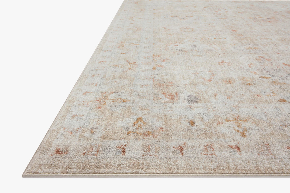 Sand-colored area rug with distressed speckle pattern and low, flat woven texture