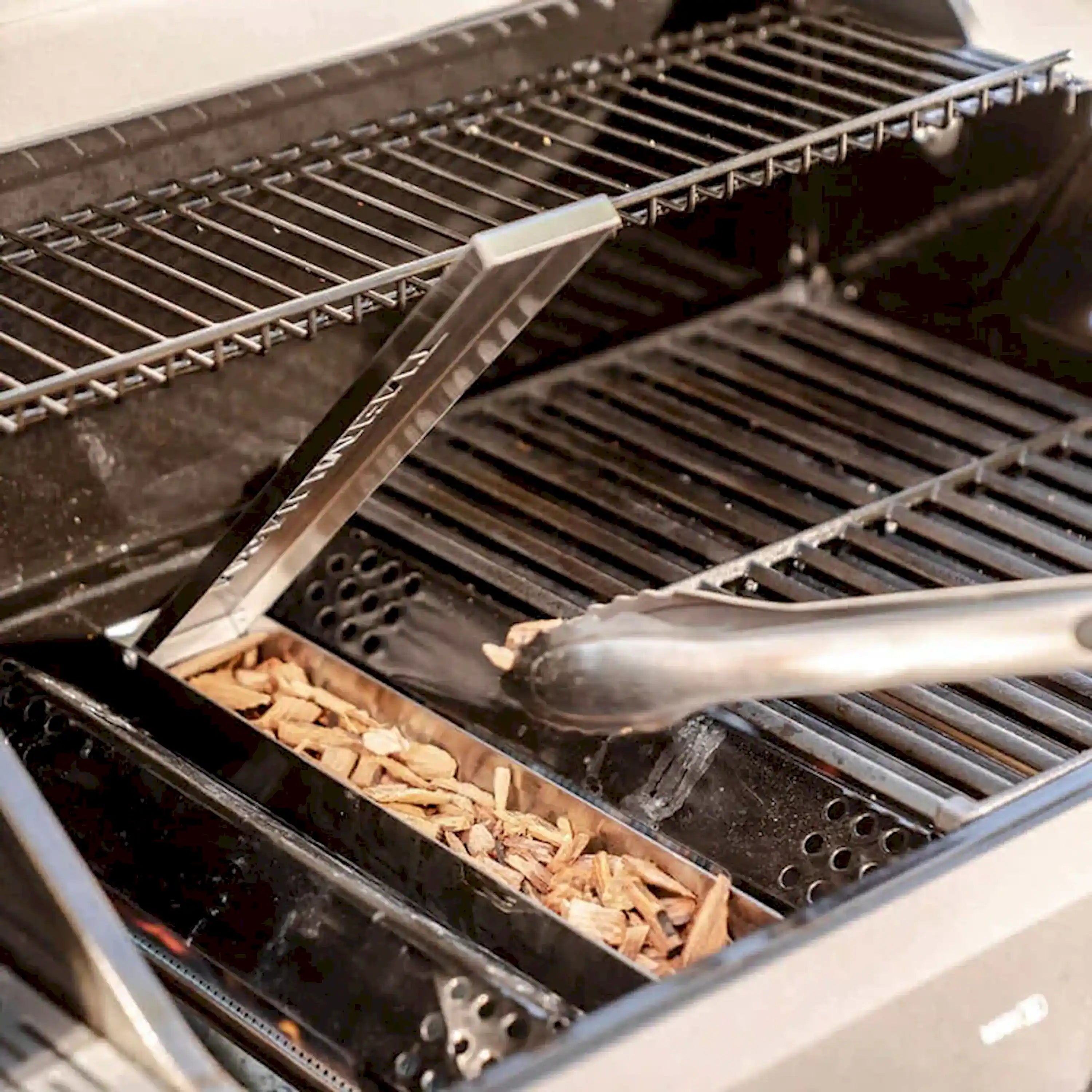 Open two-burner propane gas grill with stainless cooking grates and warming shelf