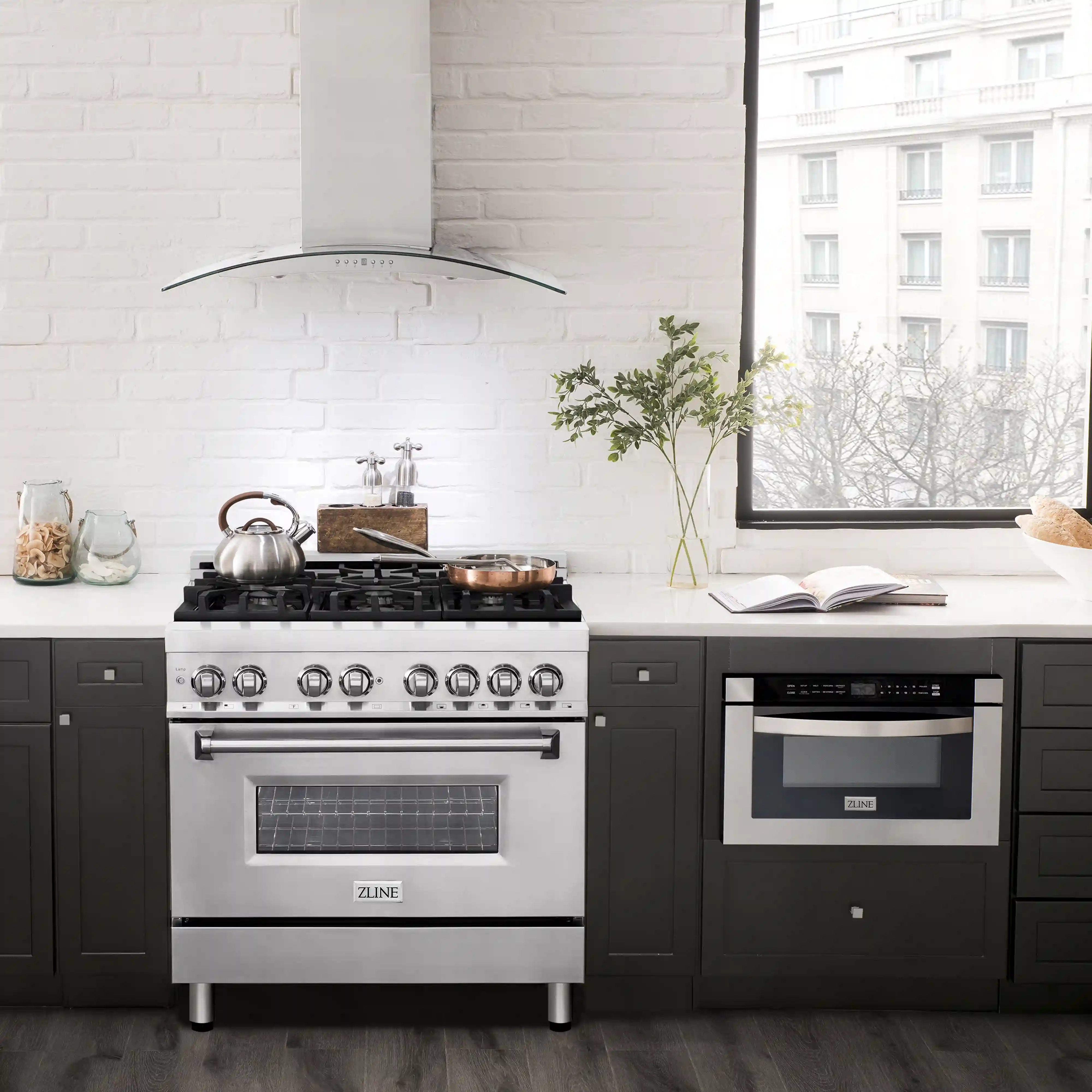 Stainless steel dual fuel range with hood, black grates, and glass window oven door
