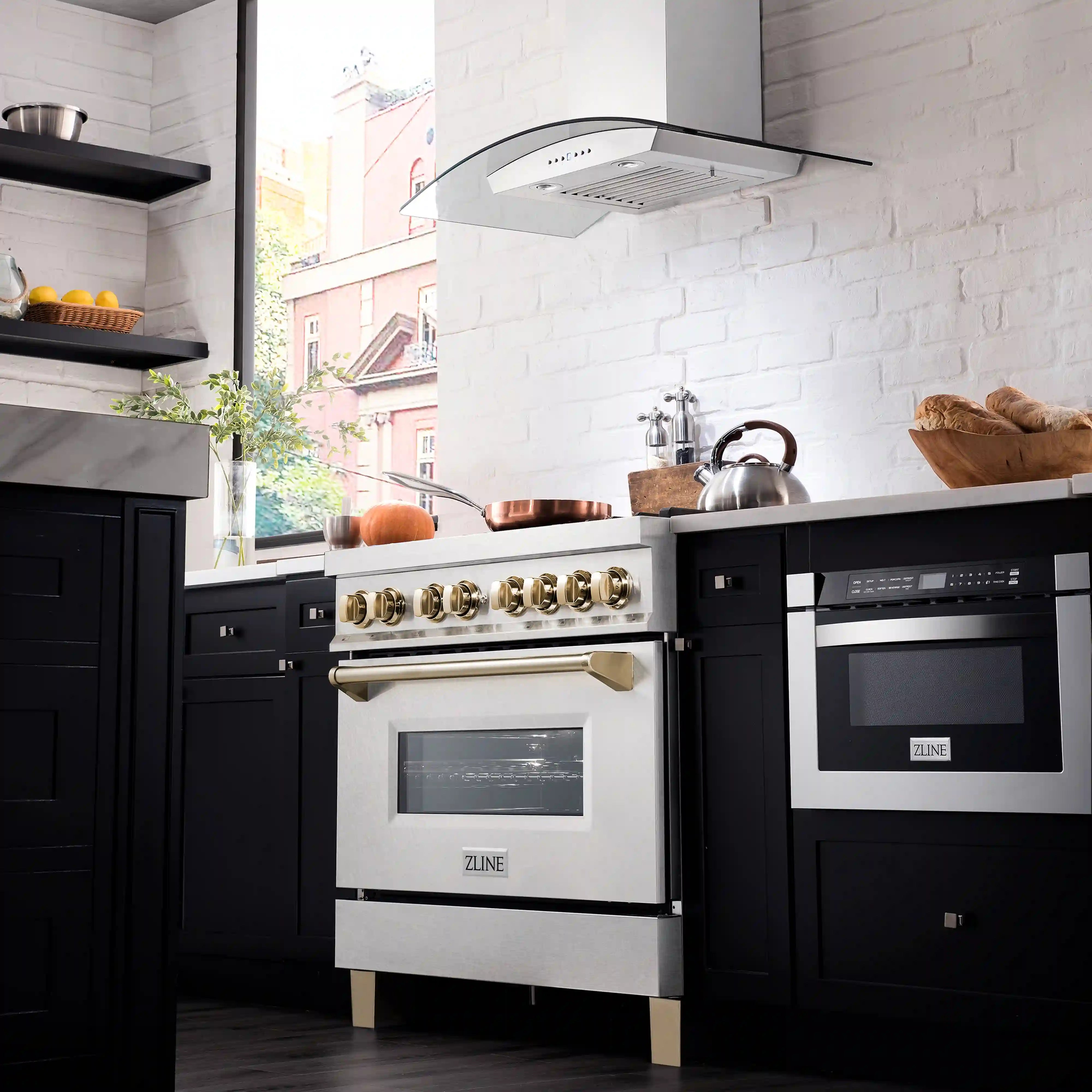 Dual fuel range with gold burner knobs, open oven compartment, and satin stainless finish