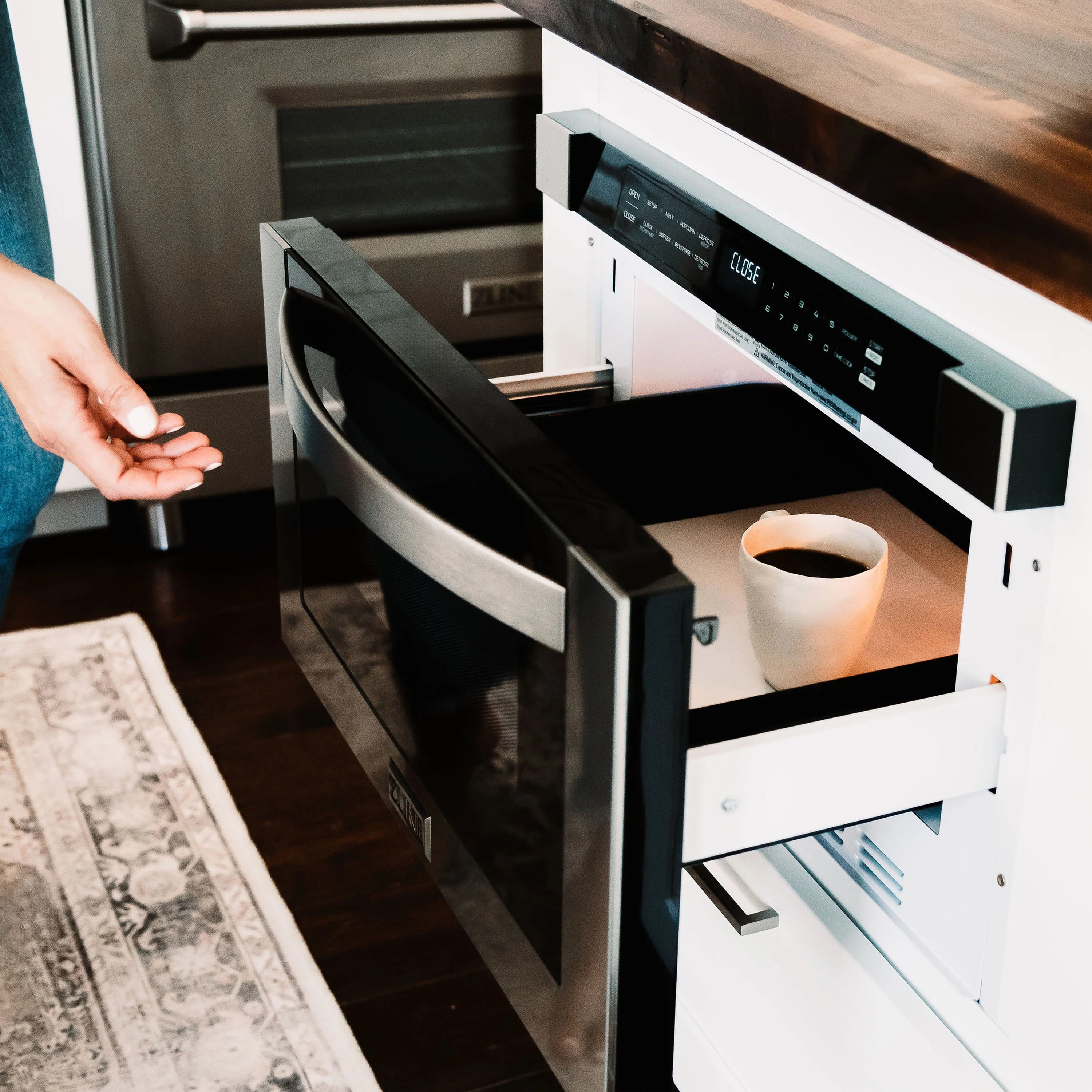 Stainless steel microwave drawer with black handle, drawer open and controls visible