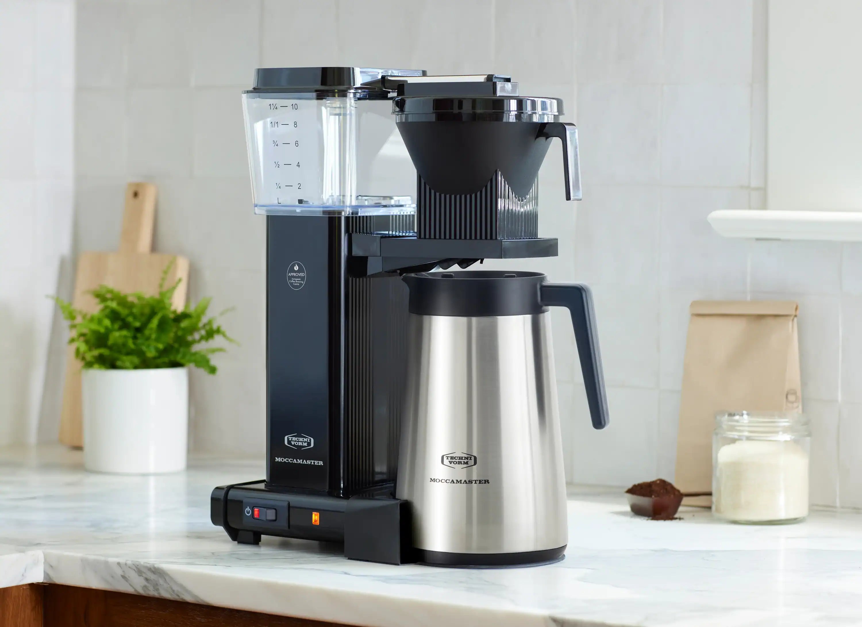 Black drip coffee maker with thermal carafe and top lid over the brew chamber