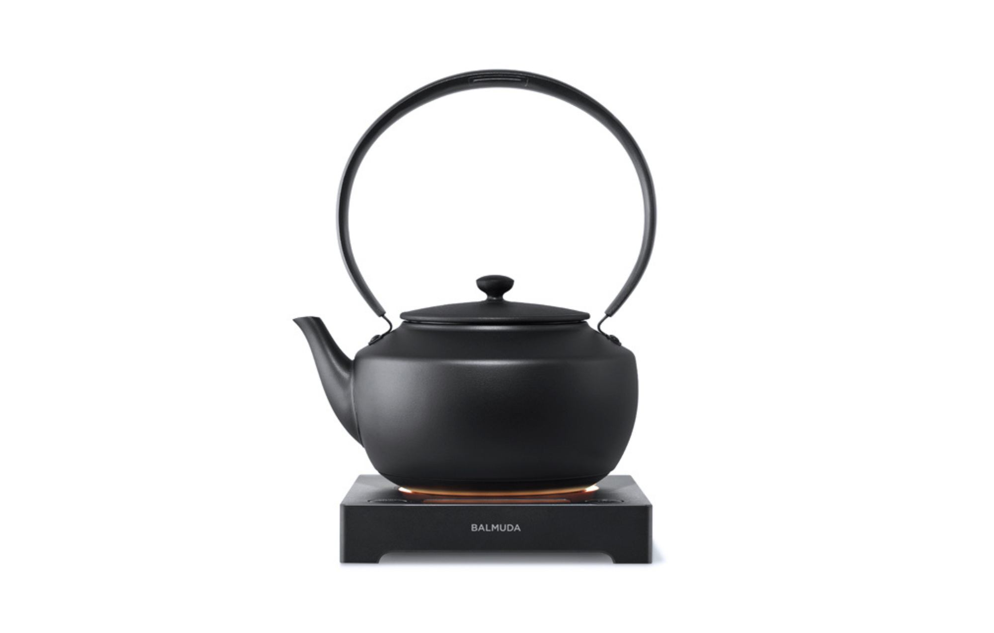 Black electric kettle with arched handle and pour spout on countertop base.