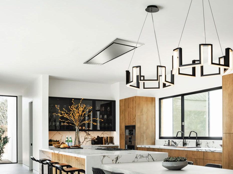 Stainless steel flush ceiling range hood mounted above a kitchen cooktop