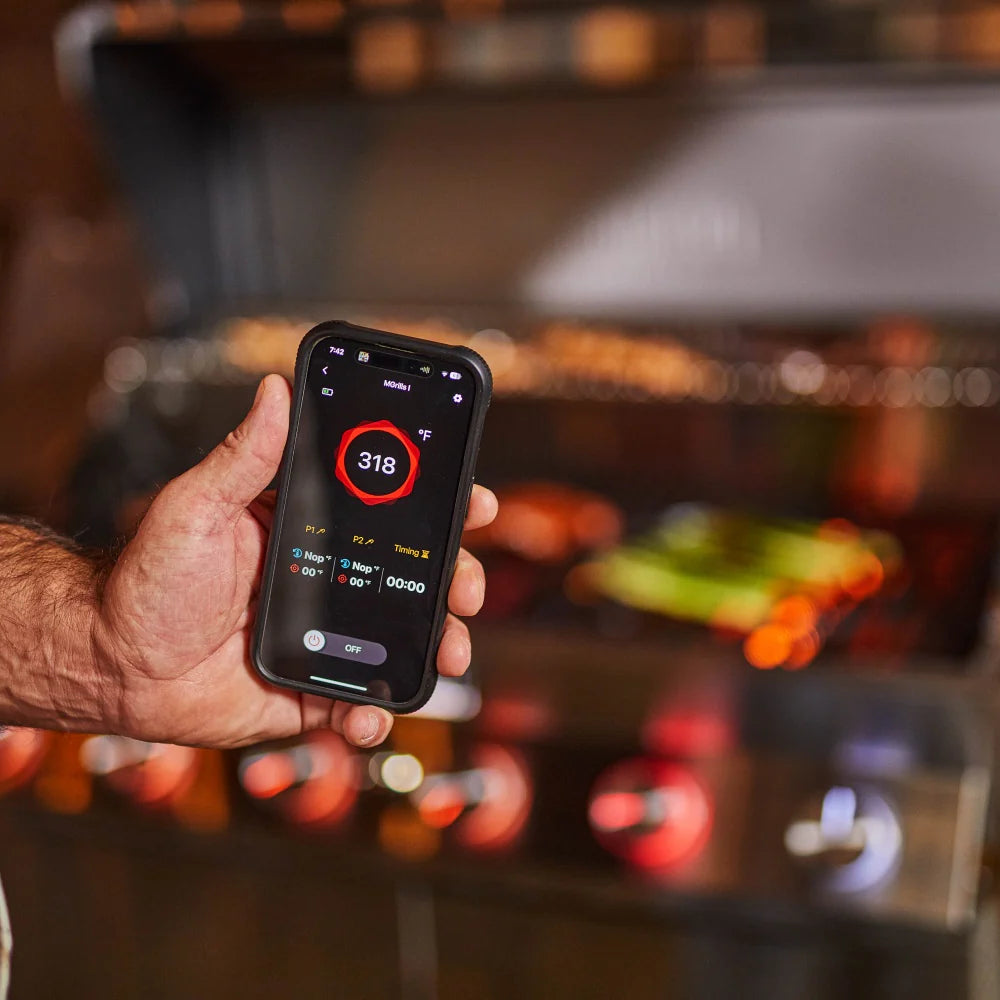 Hand using a smartphone app to control a smart propane gas grill temperature