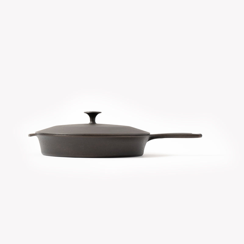 Cast iron skillet with lid and long loop handle, dark charcoal cast-iron surface