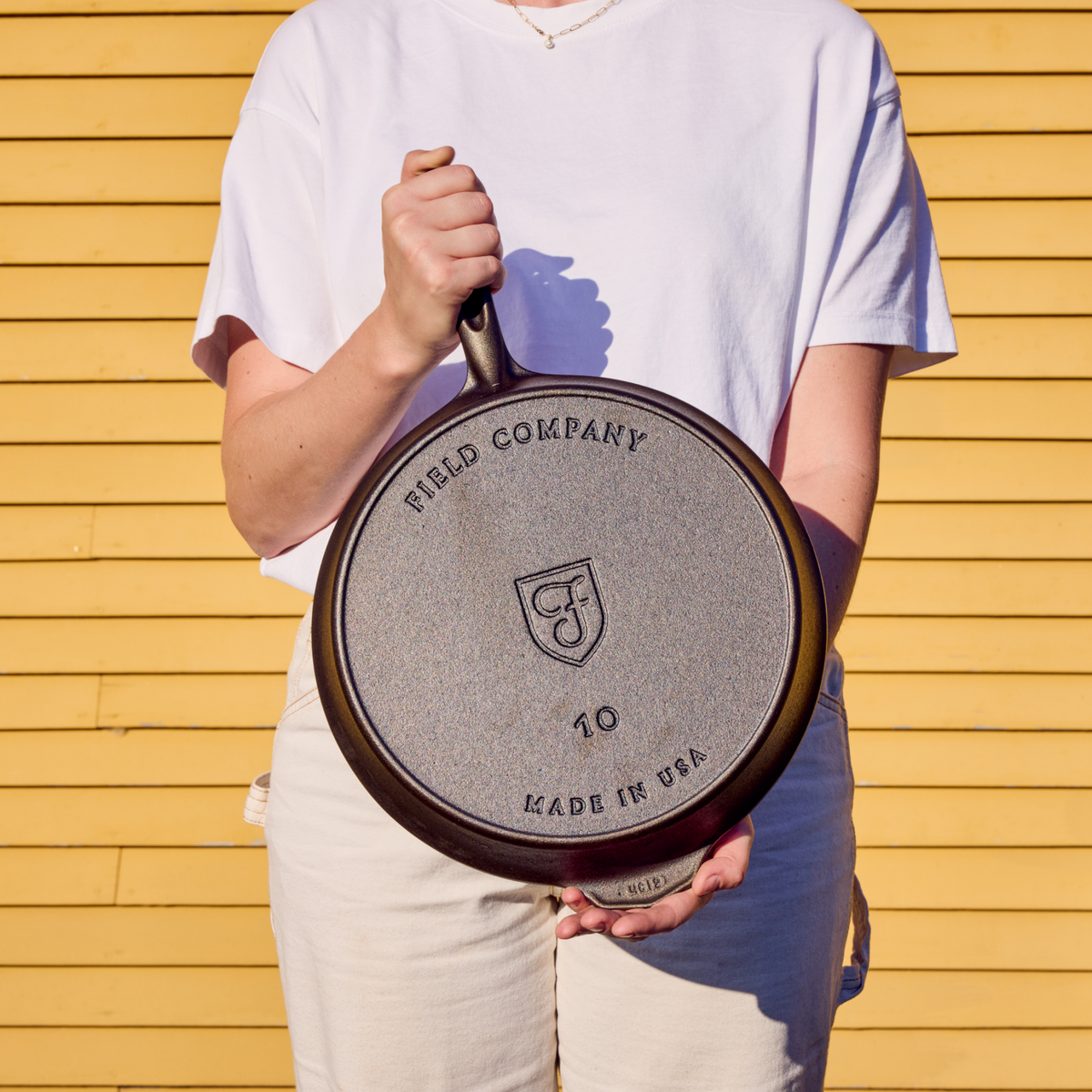 Cast iron skillet base with Field Company logo, shown from underside with loop handle.