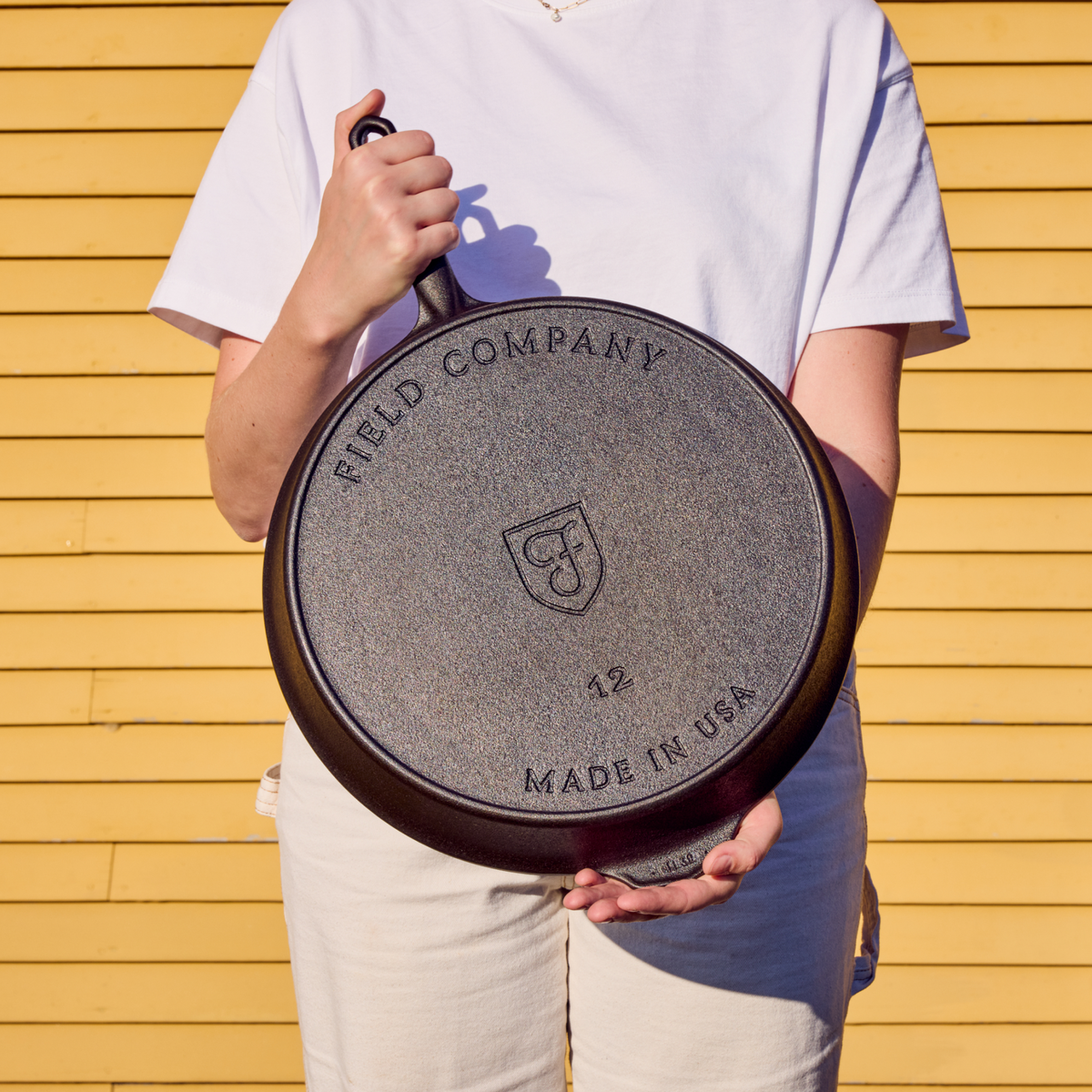 Field Company No.12 cast iron skillet held with underside showing branding