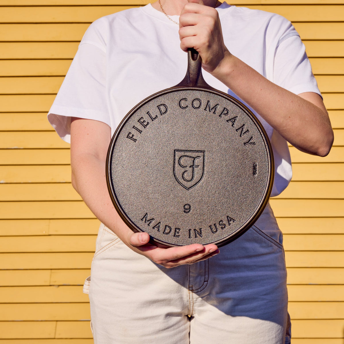 Round cast iron griddle with Field Company logo on the cooking side and handle