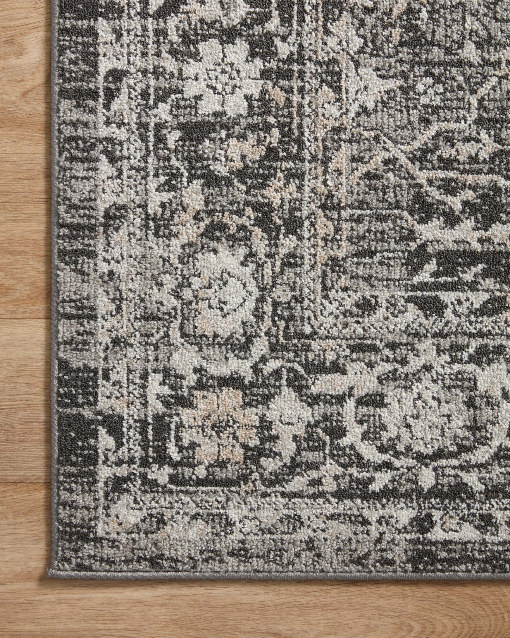 Charcoal and silver runner rug corner with detailed scrolling motif