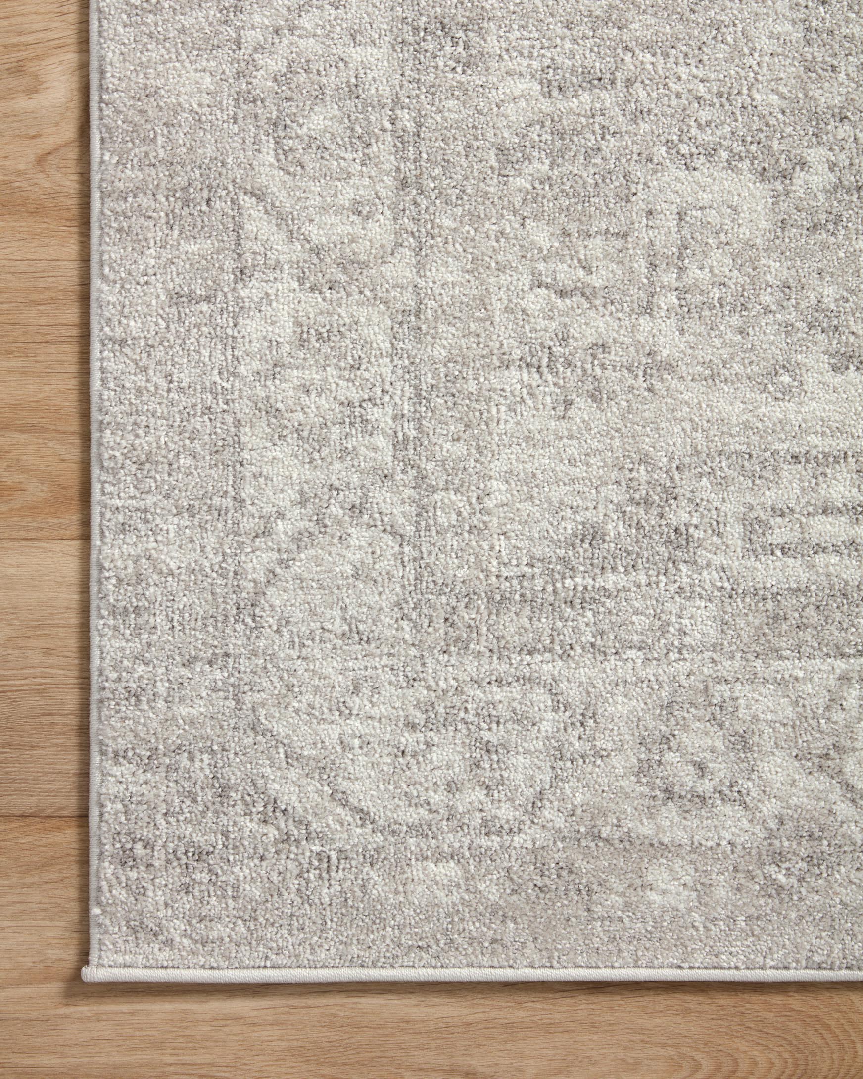 Area rug with silver-gray and ivory textured pattern, straight border edge