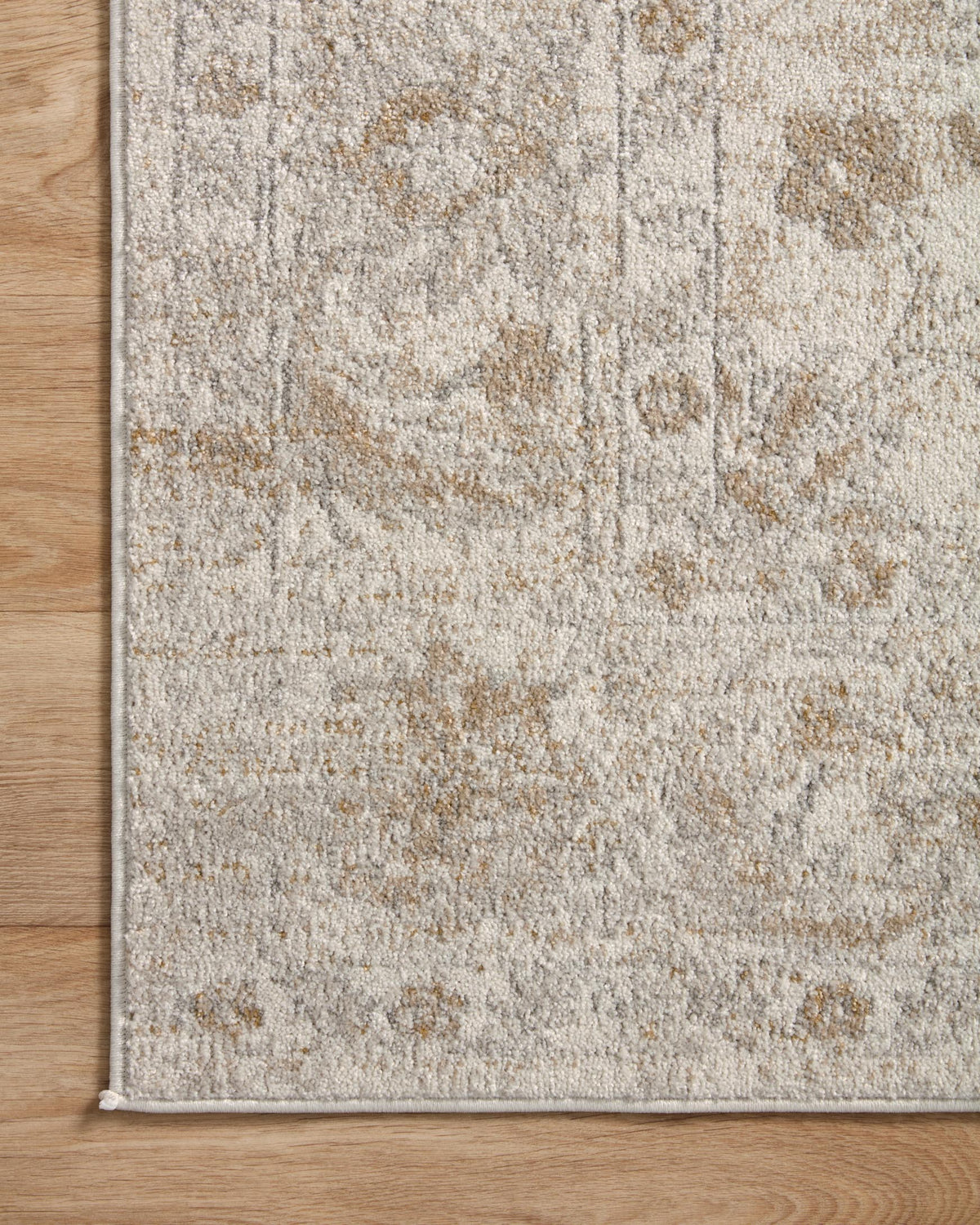 Ivory and beige traditional area rug edge with subtle distressed pattern details