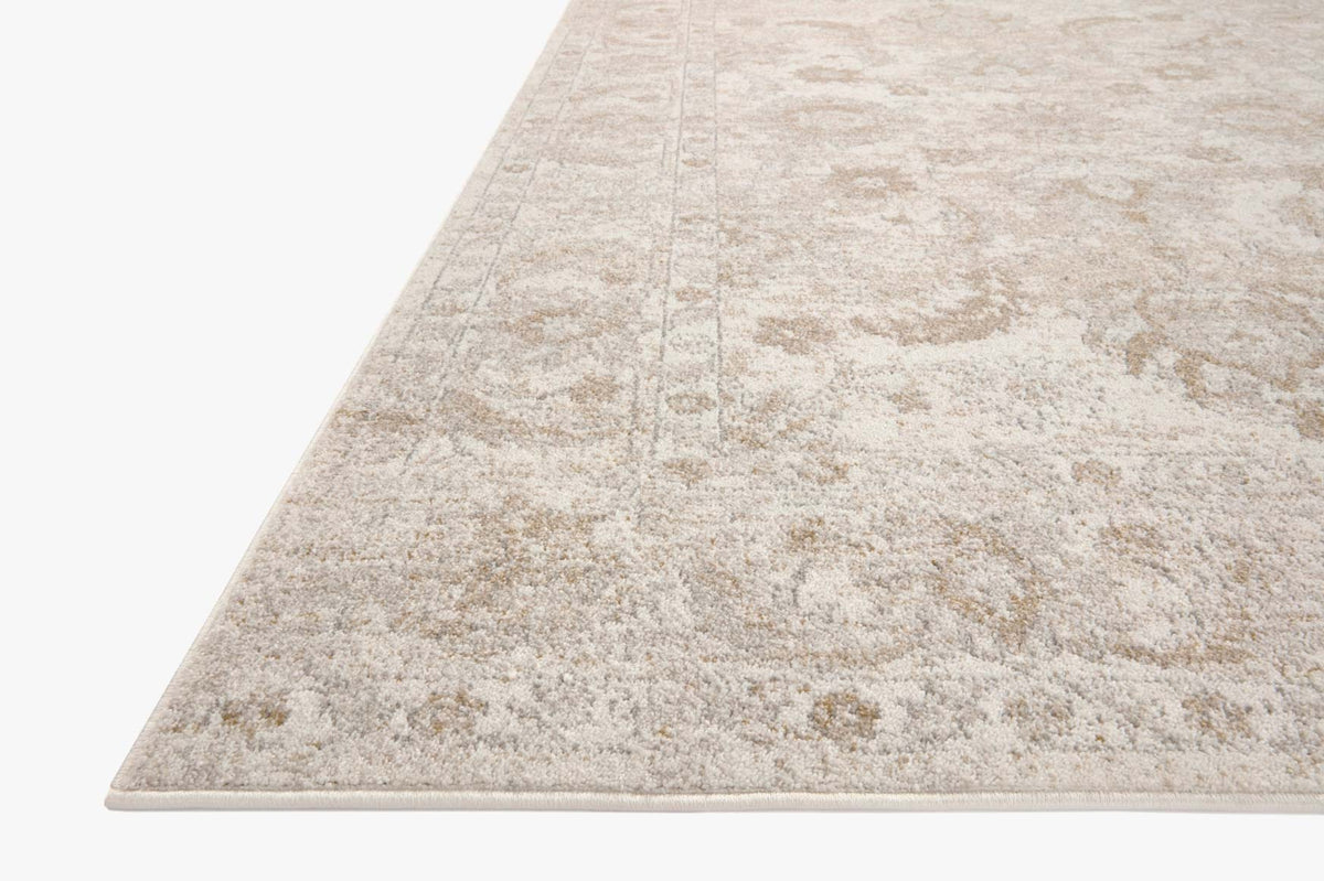 Traditional area rug in ivory and beige with distressed medallion-style pattern