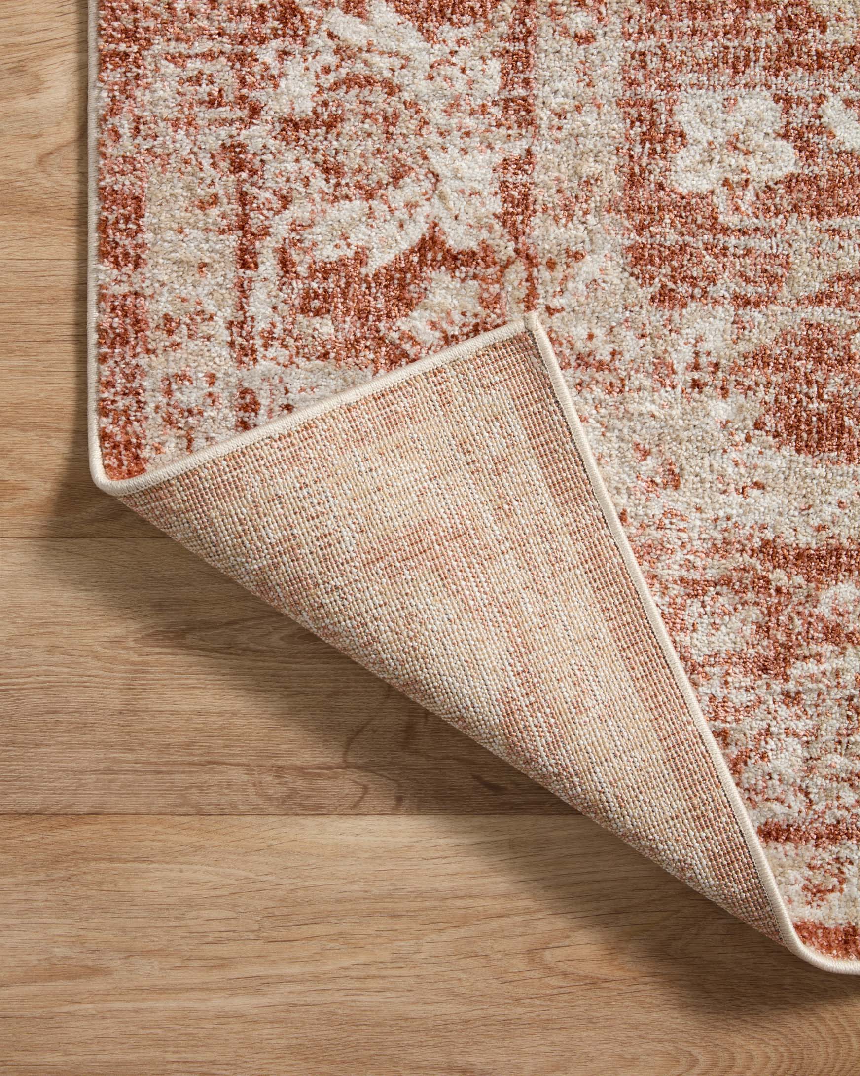 Rust and ivory area rug edge detail with woven backing and trimmed border