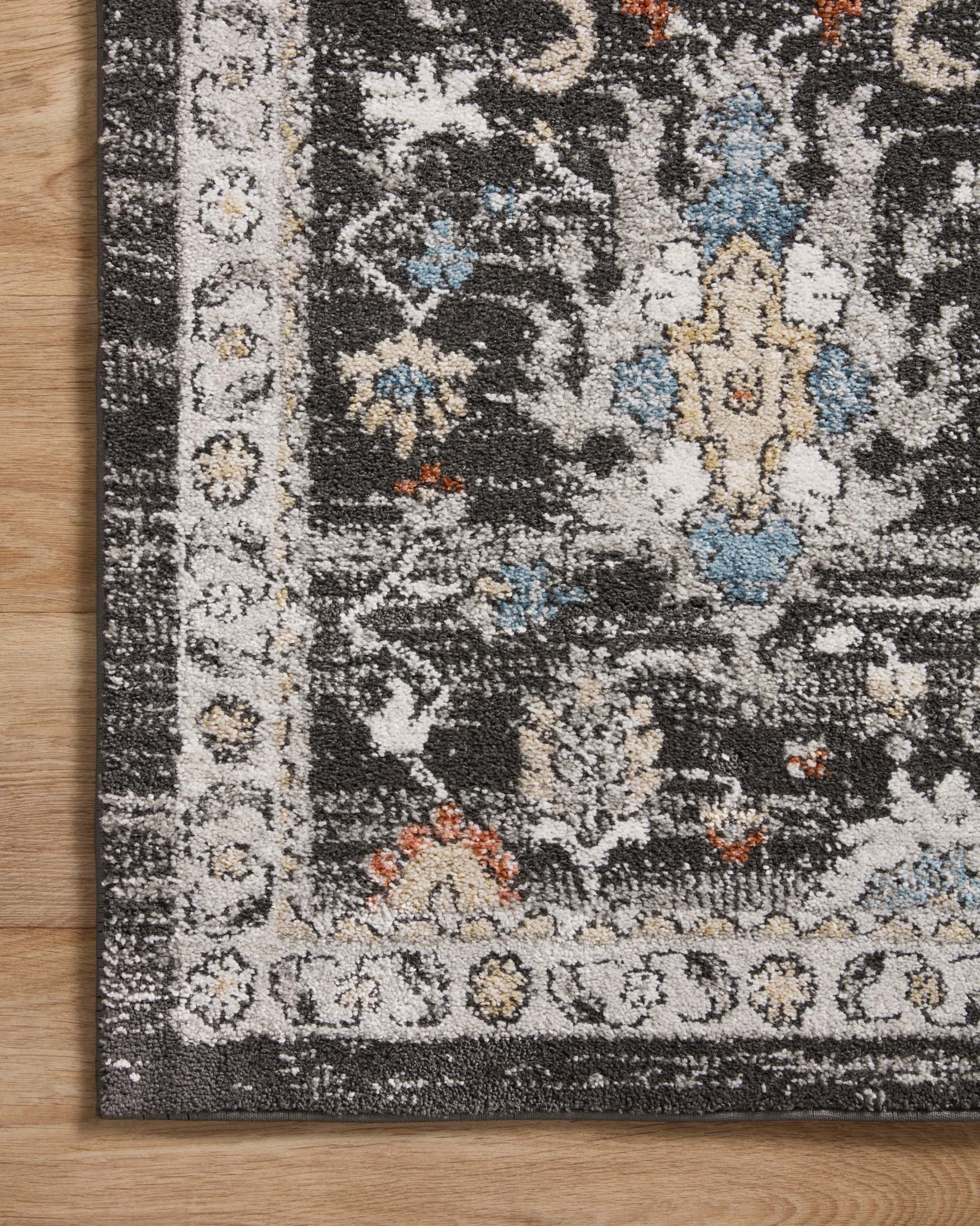 Charcoal traditional area rug with ornate border and scattered medallion motifs