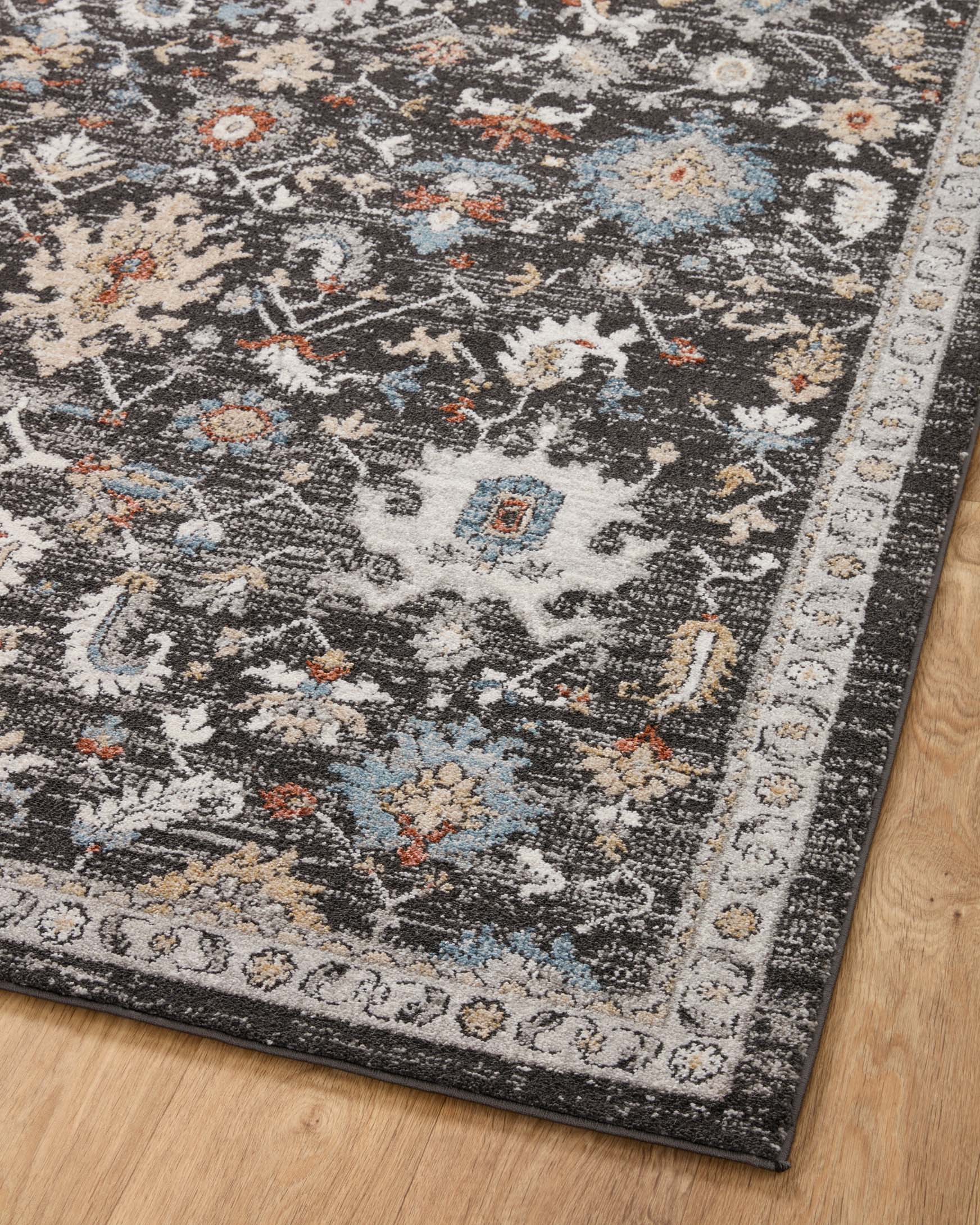 Charcoal runner rug diagonal view with distressed multicolor motifs and ornate border