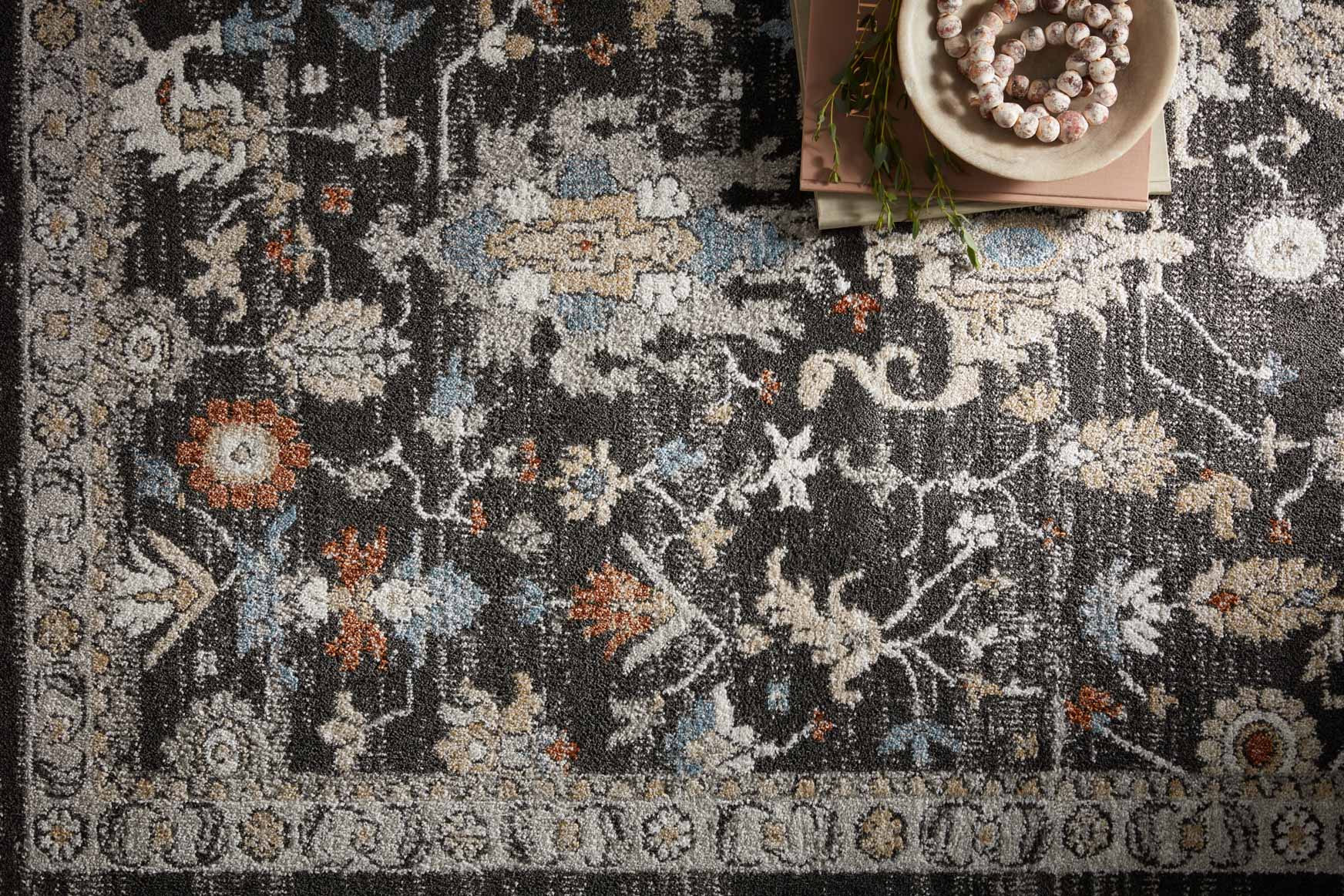 Close-up of charcoal runner rug with distressed multicolor motifs and textured pile