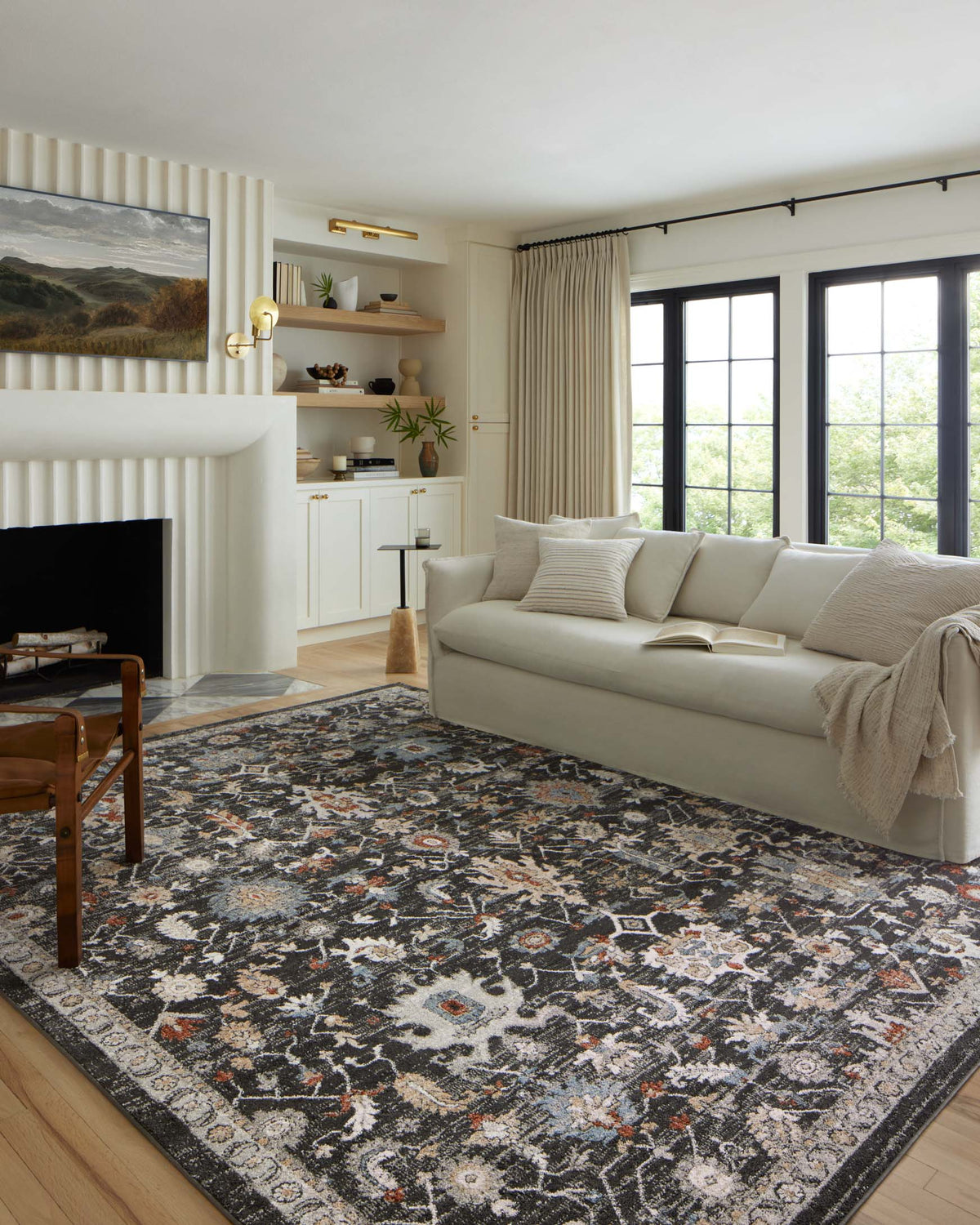 Traditional charcoal accent rug with ornate pattern and border in a living room setting