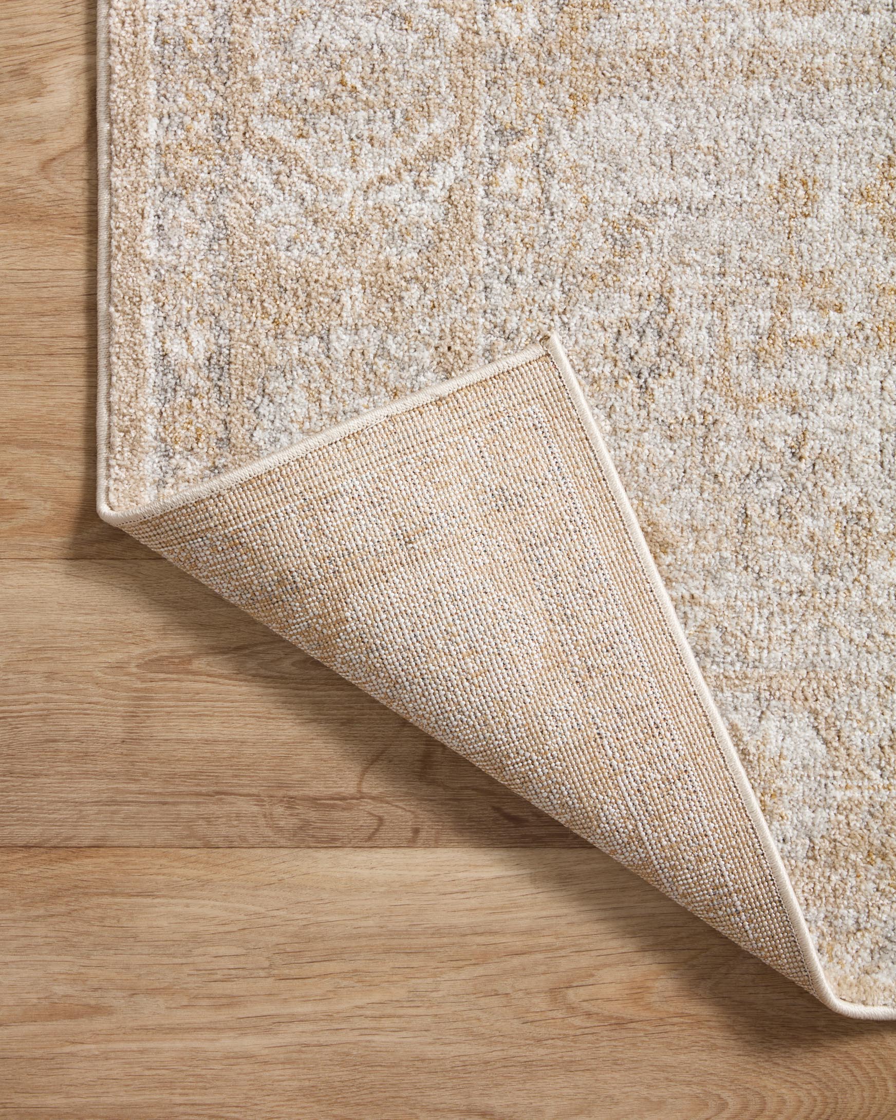 Traditional beige and silver area rug corner showing textured underside and distressed weave