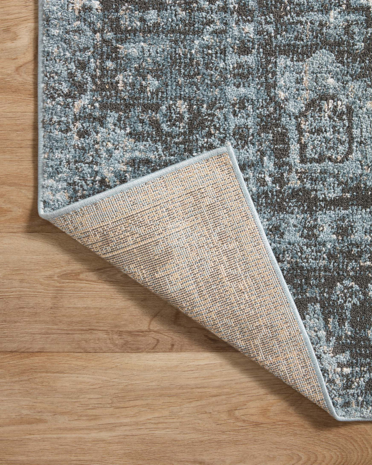 Blue-gray and charcoal rug corner detail showing backing and textured edge