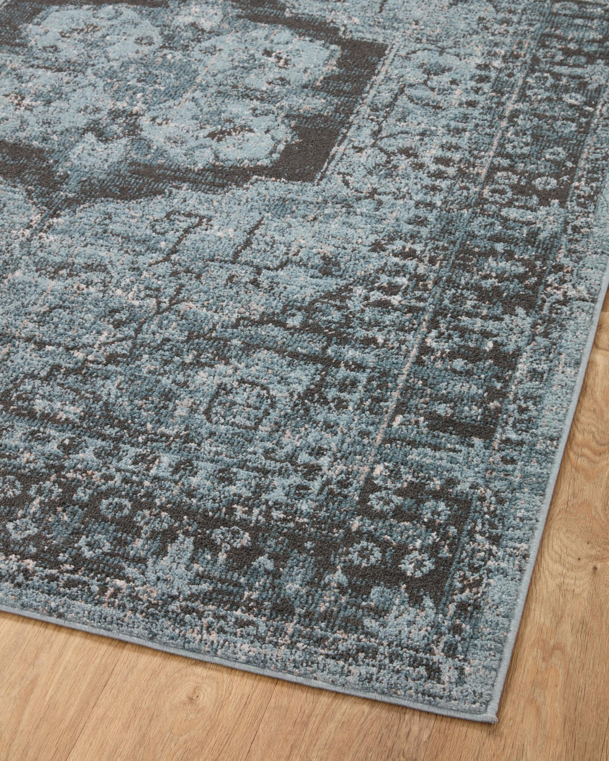 Rectangular close view of sky-blue and charcoal distressed area rug pattern