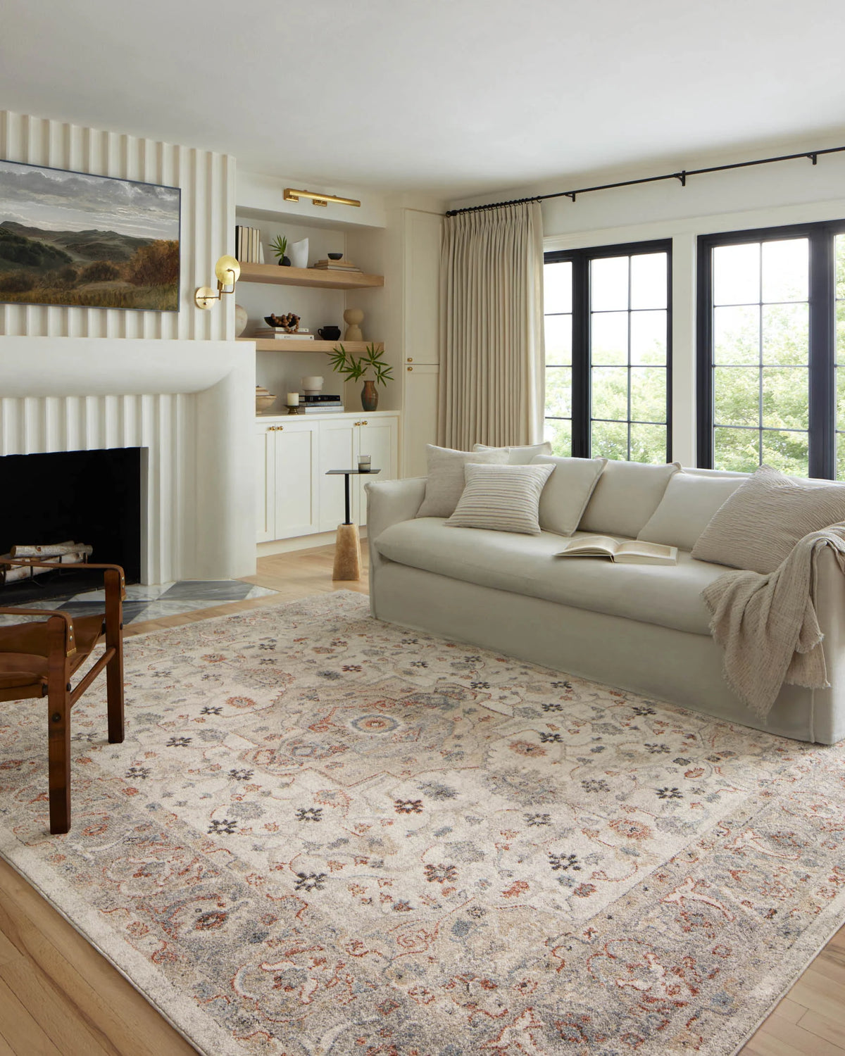 Ivory traditional area rug with blue and orange motifs, styled in a living room