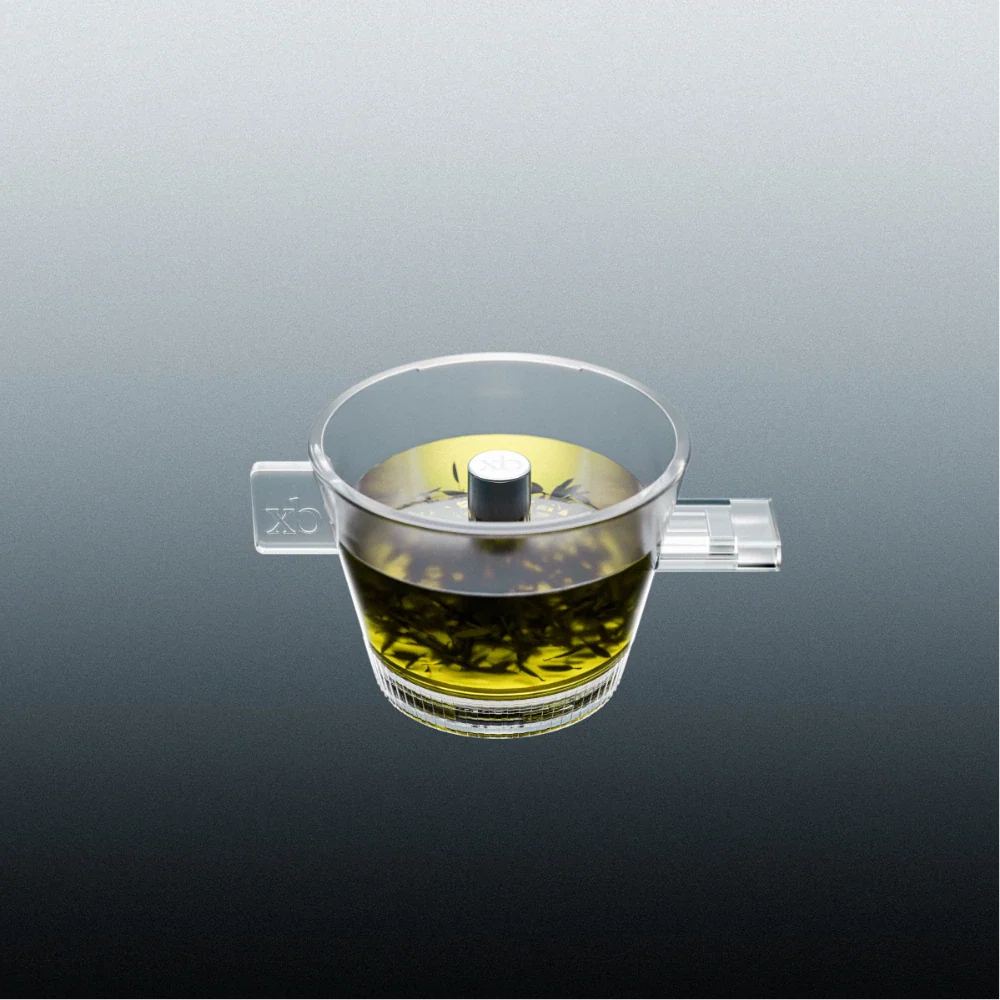 Clear Omni tea brewer with yellow tea liquid and upper metal control knob