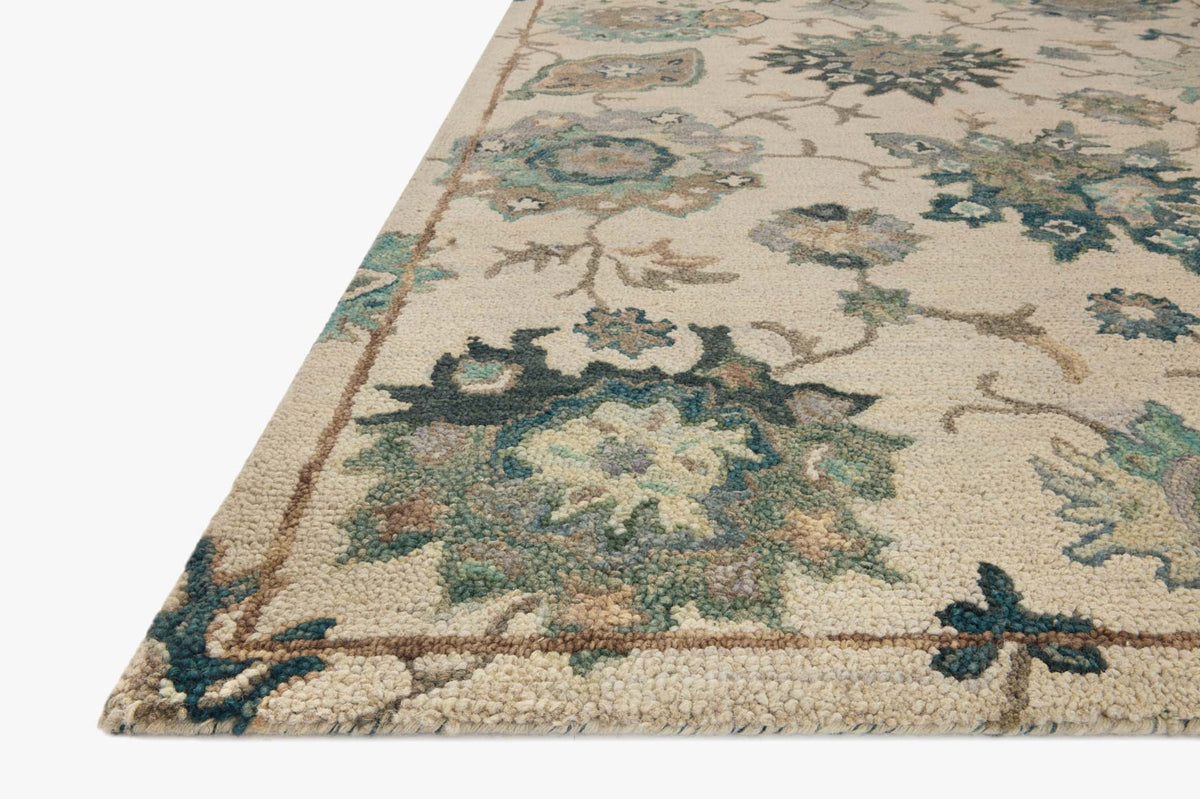 Ivory area rug with teal and blue floral medallion pattern and beige border