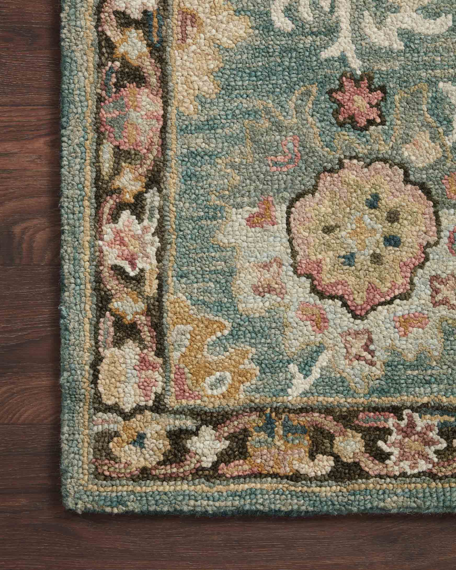 Teal floral accent rug edge with multicolor medallion border on dark wood floor