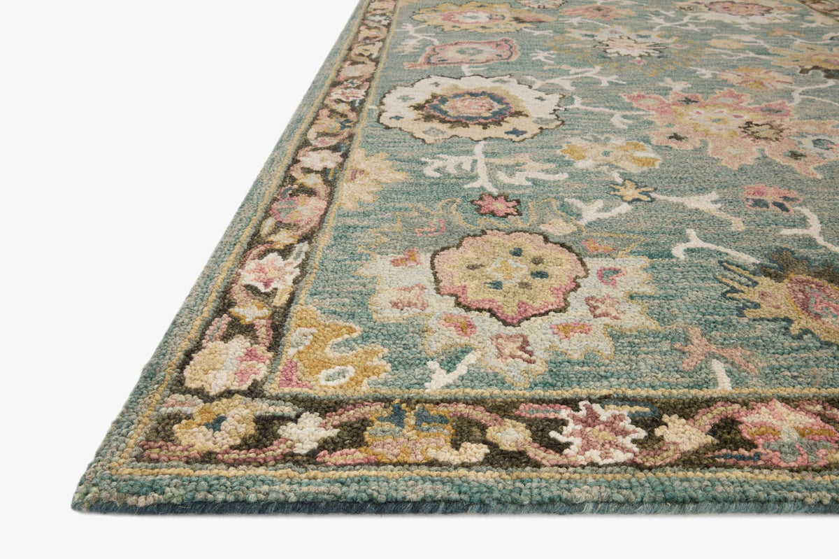 Teal accent rug with multicolor floral motifs and decorative border, corner view
