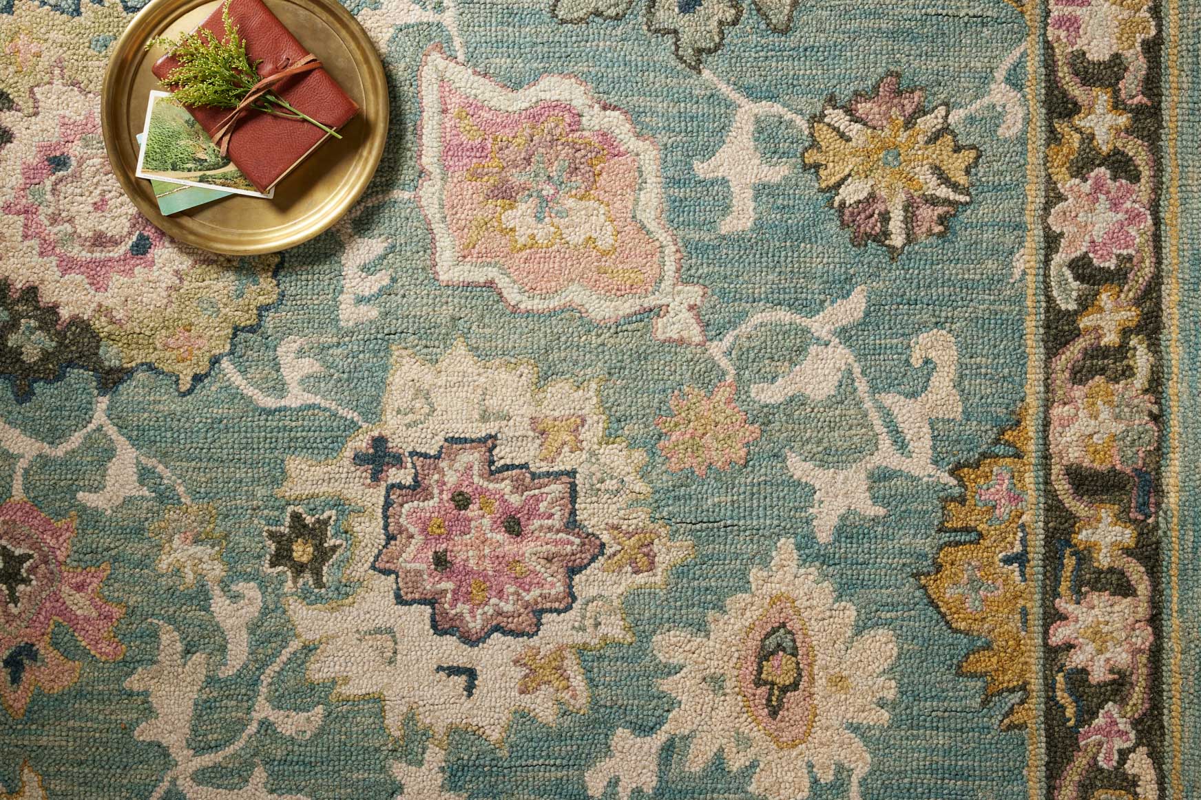 Teal rug close-up with detailed multicolor floral and star motifs