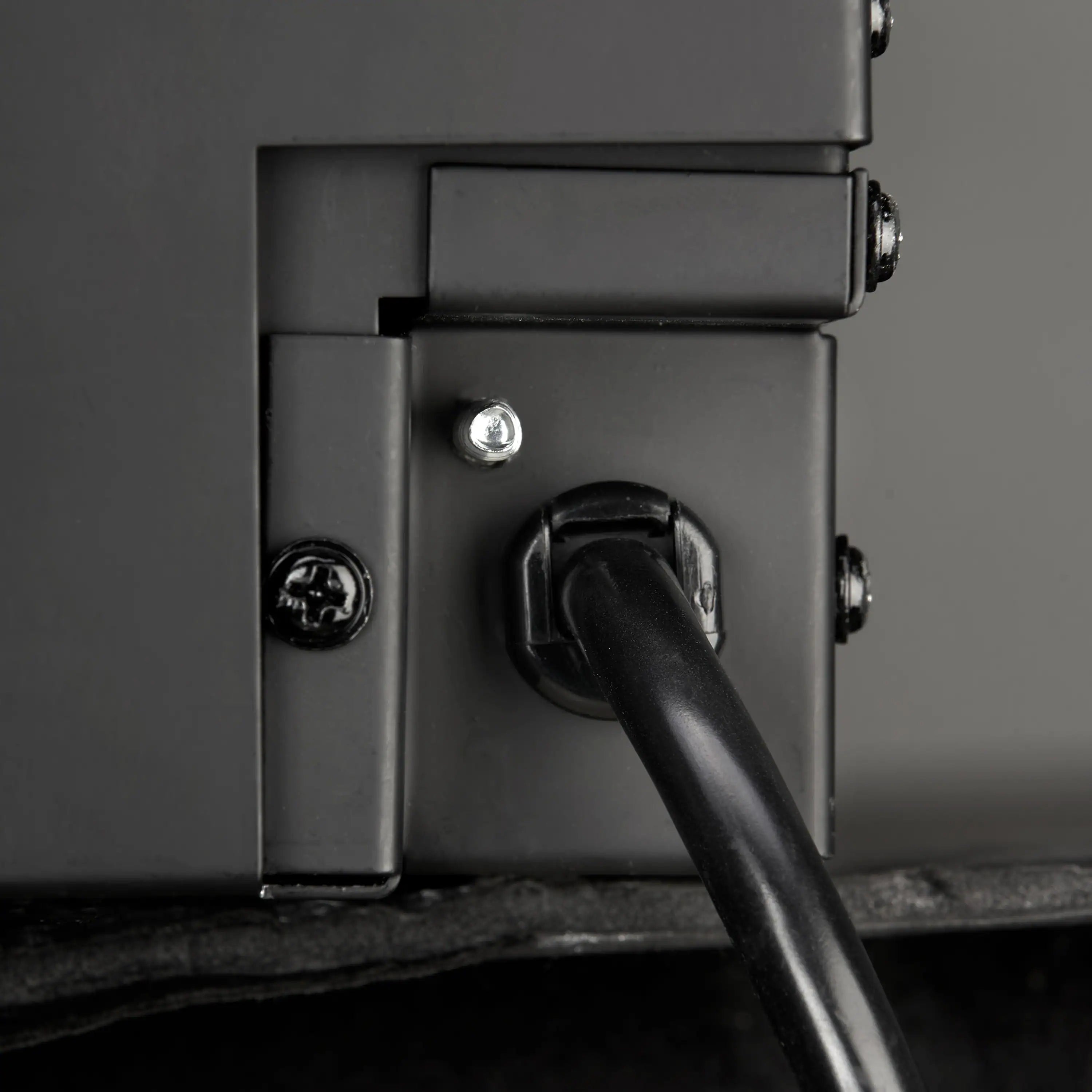 Built-in linear electric fireplace control panel with dark metal switch and screws
