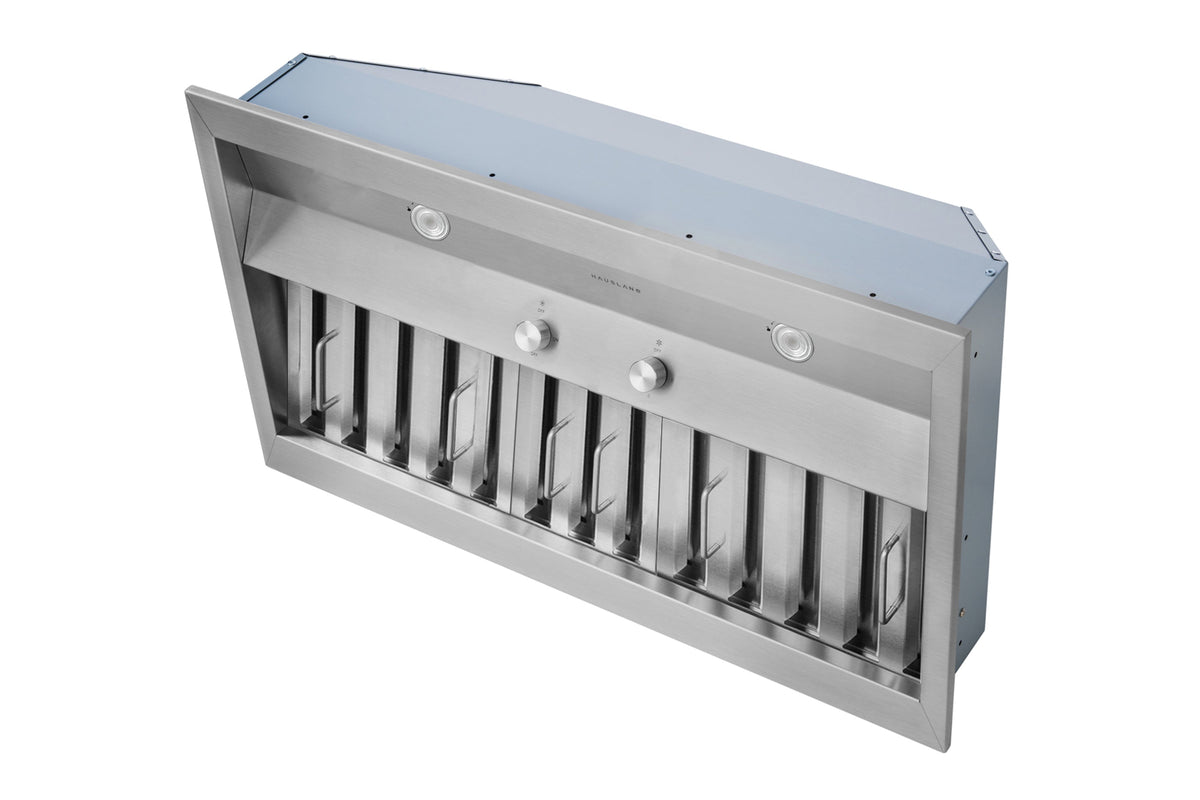 Stainless steel built-in range hood insert angled view with front vent louvers and knobs.